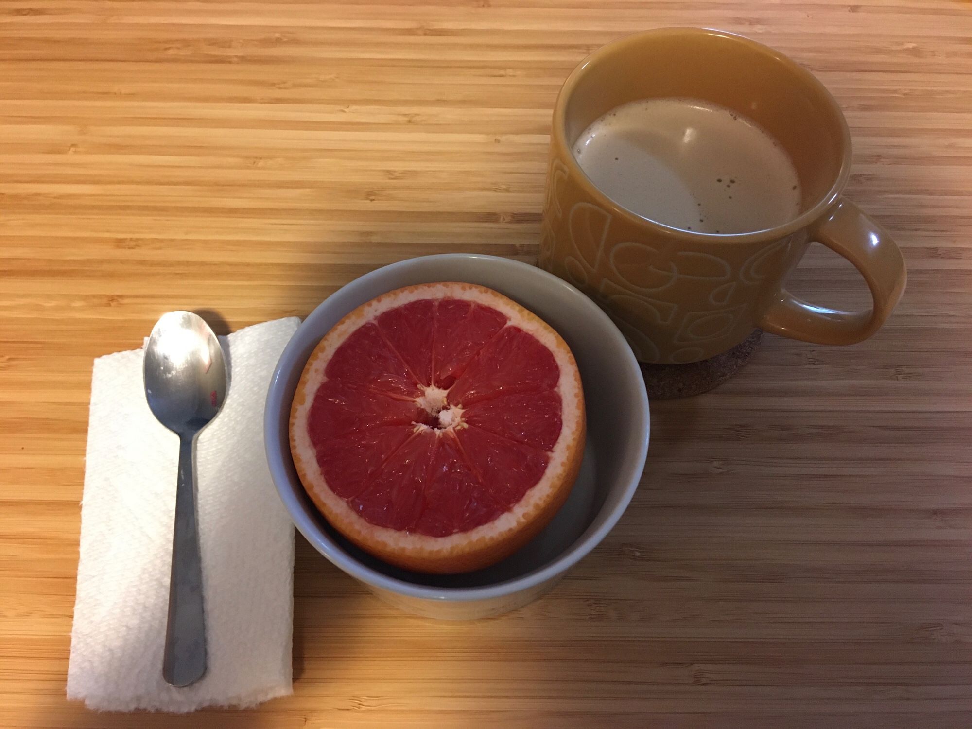 A cup of coffee and half a grapefruit