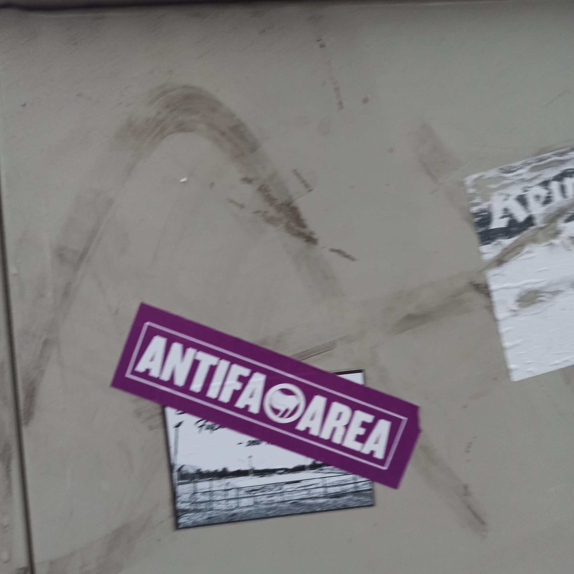 Foto eines Stickers auf einem Verteilerkasten Der Sticker ist pink Darauf ist zu lesen Antifa Area