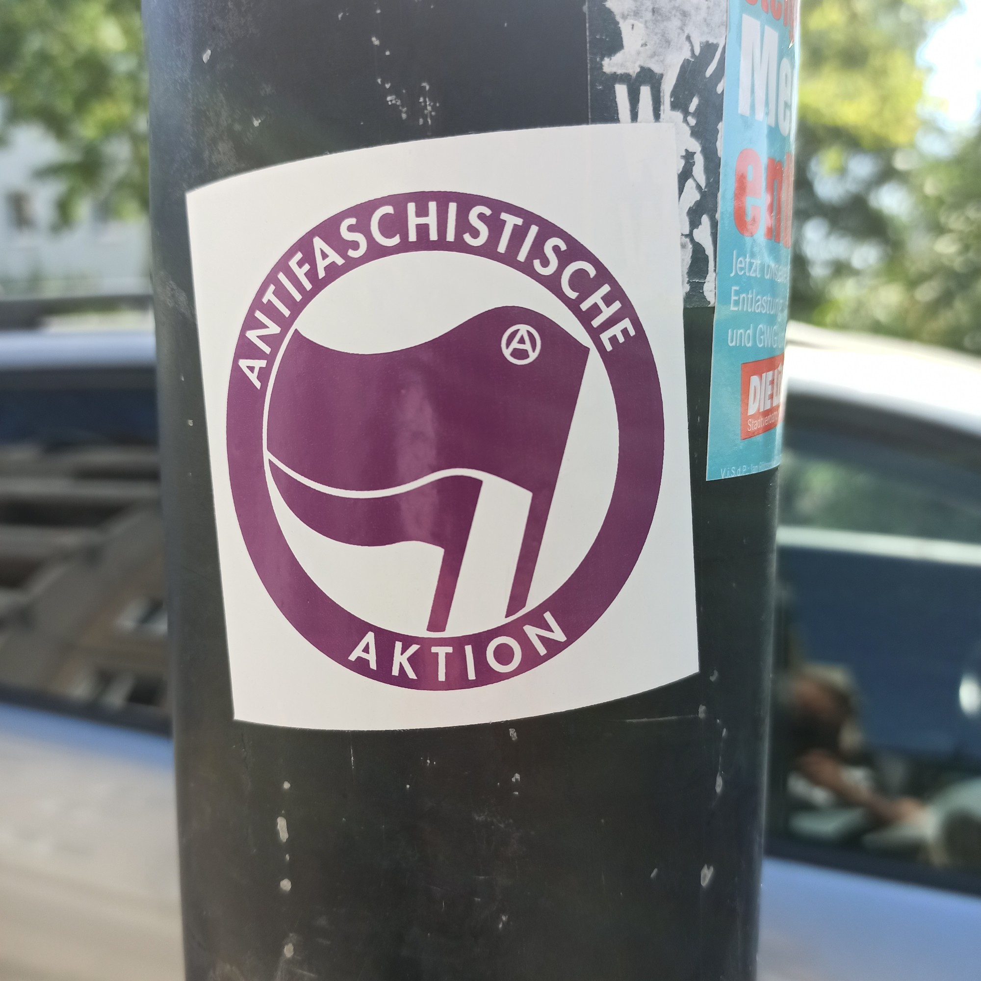 Antifa Sticker auf Laternenmast. Pinke Farbe das Antifa Symbol