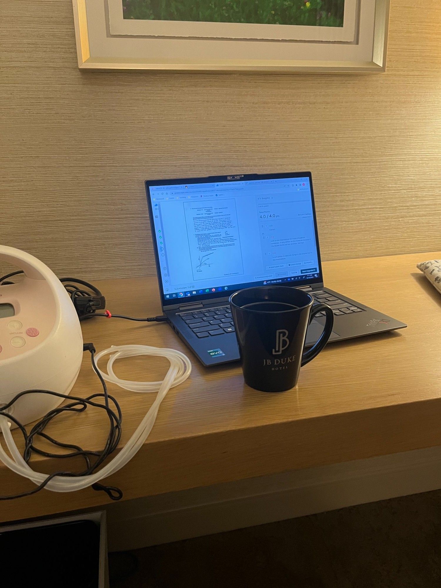 Computer with coffee mug and breast pump on desk at hotel