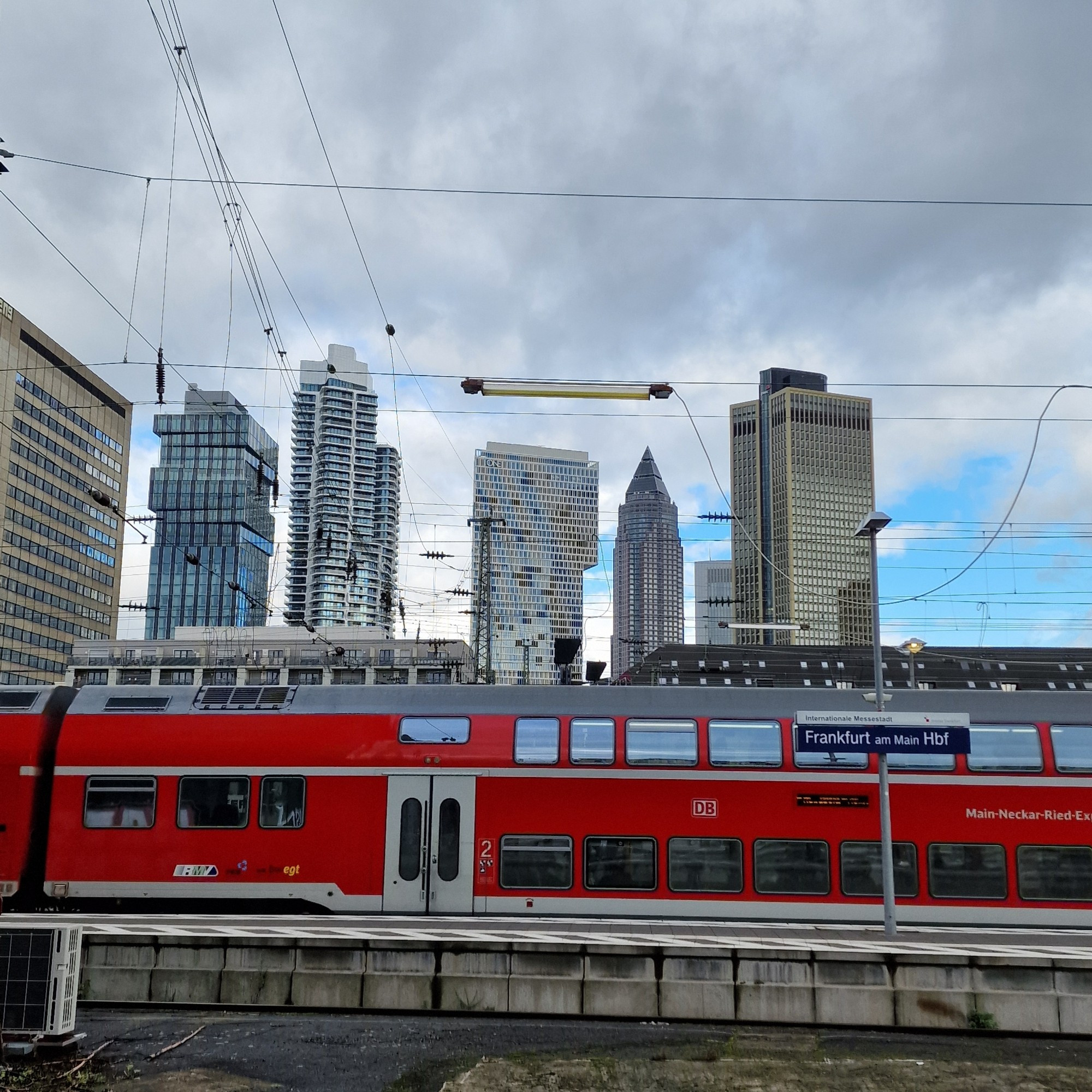 Hochhäuser in Frankfurt vom Hauptbahnhof fotografiert. Der Messeturm und One. Den Rest kann ich namentlich nicht benennen. Ein RE steht zwei Gleise weiter.