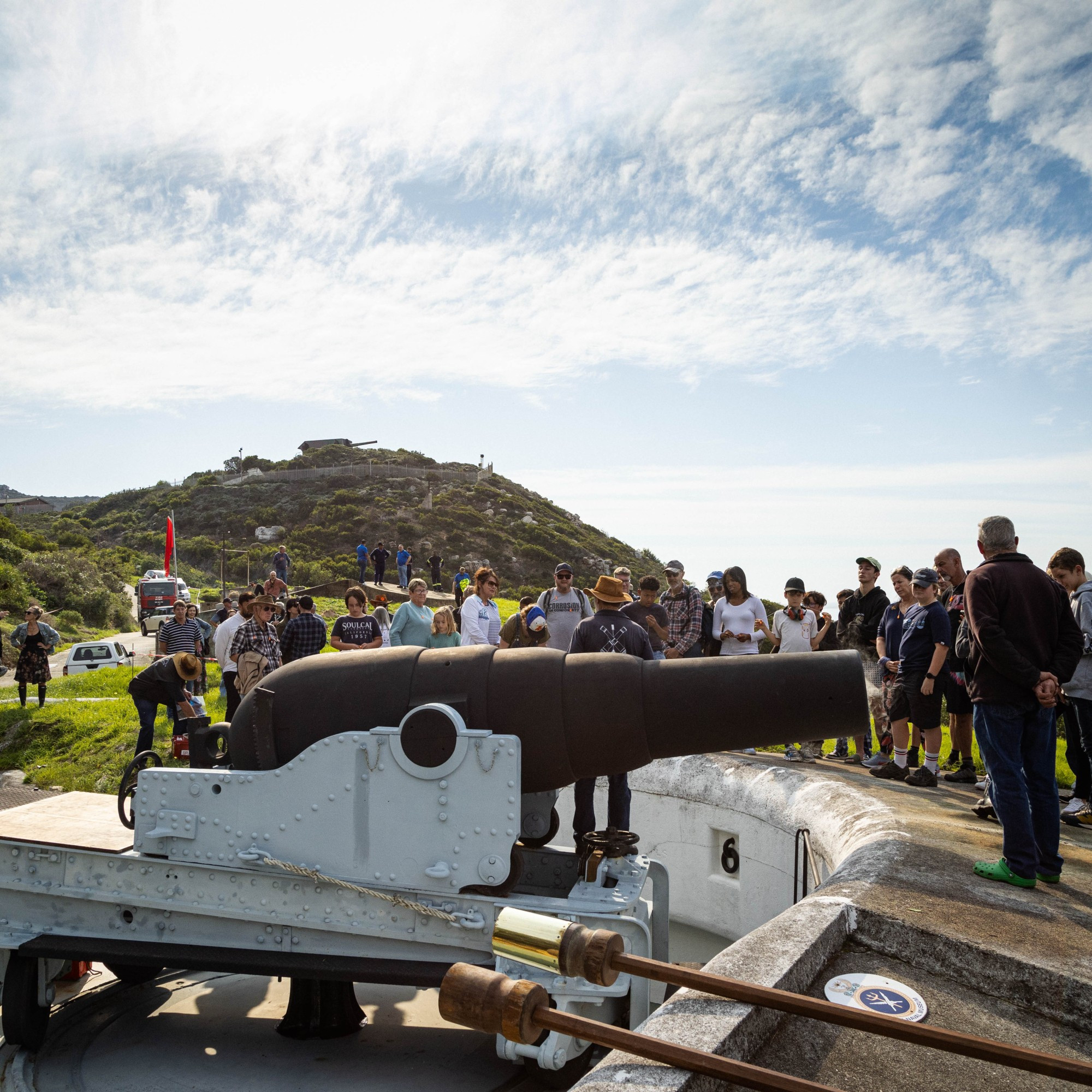 Nine inch rifled muzzle loader after being fired. Crowd looking on.