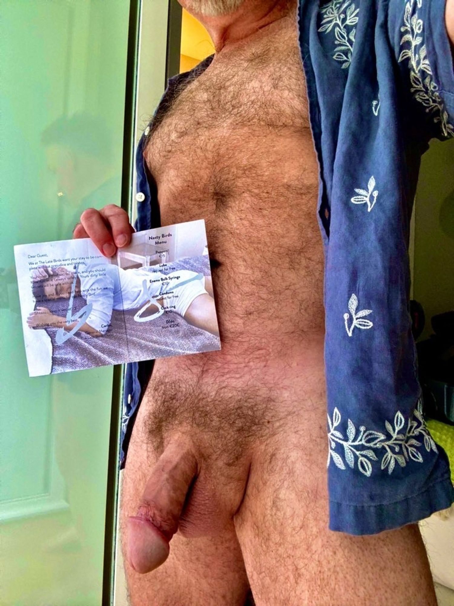 Furry naked Dad wearing only an unbuttoned blue shirt with white floral trim and holding a small paper menu (thick soft cock visible).