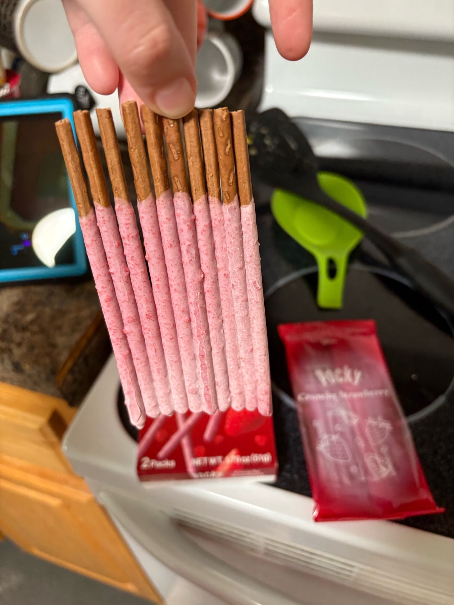 10 sticks of pocky all in a line stuck together by the dipped part. I am holding them from the undipped part of only one of them. 