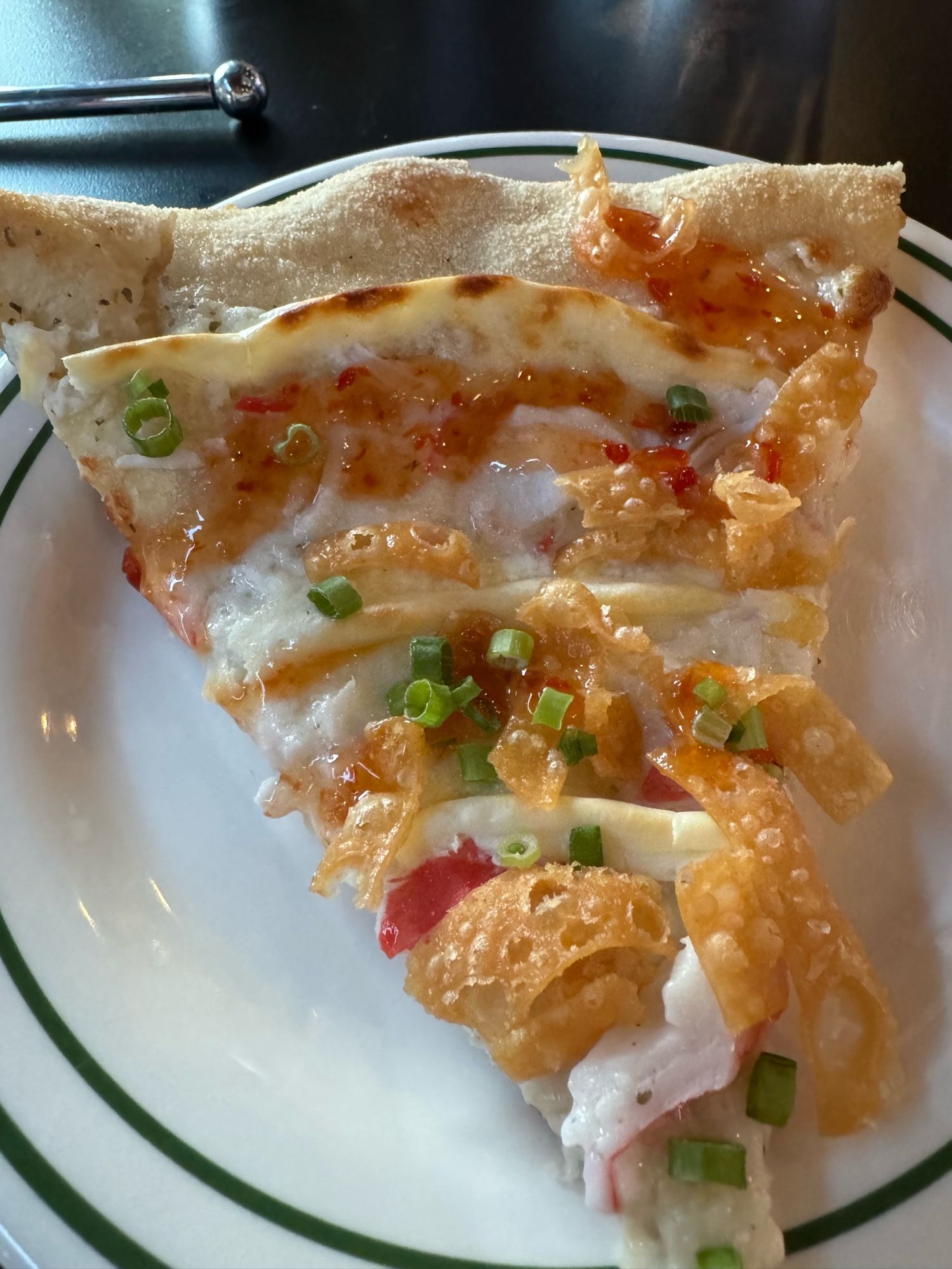 A slice of crab Rangoon pizza that has the shell and the crab as toppings.