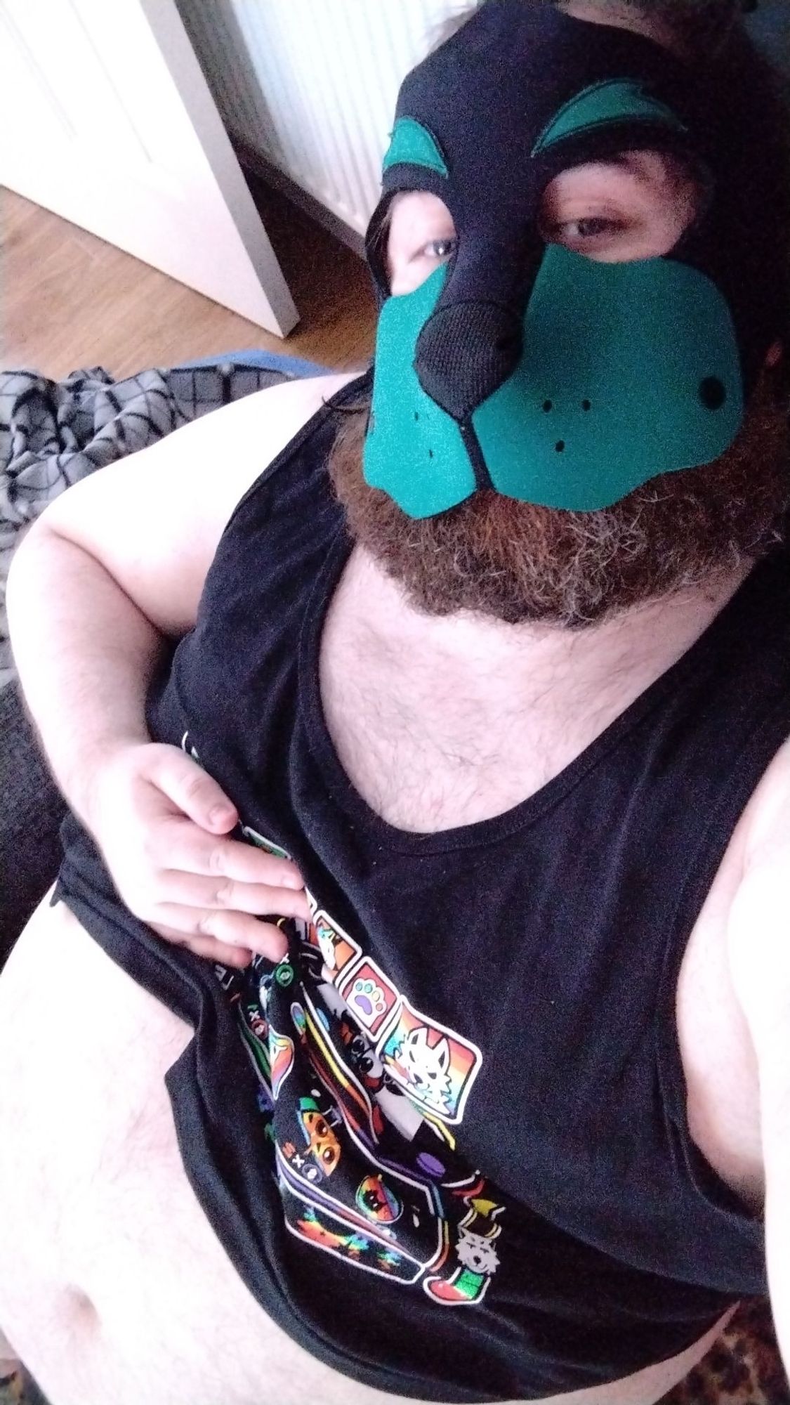 Me in my pup hood and crop top, with me holding my crop top so my belly is showing.