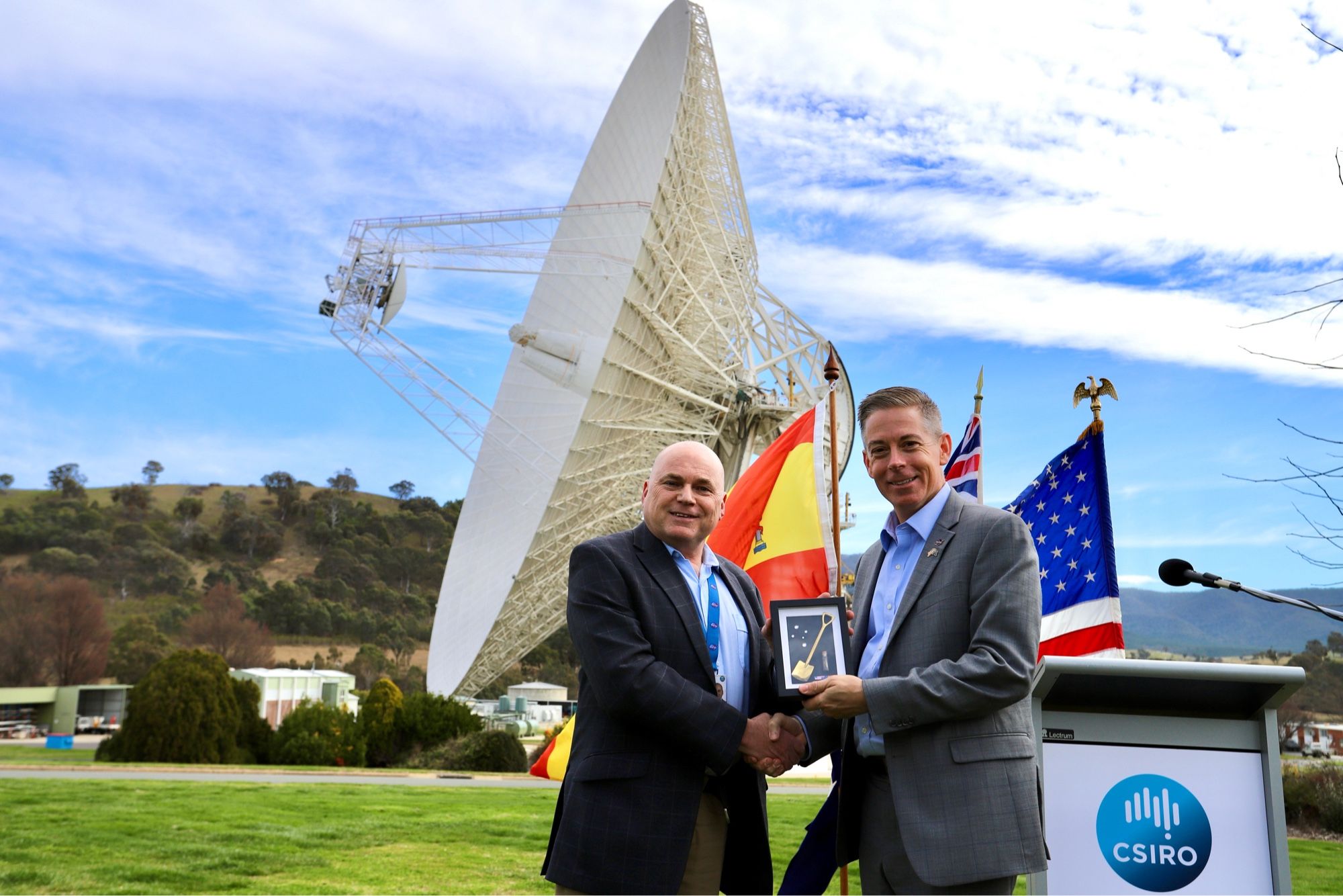 @CanberraDSN Director, Kevin Ferguson presents a commemorative plaque to NASA SCaN’s Kevin Coggins. The 70-metre antenna, Deep Space Station 43 is in the background as it communicates with the Voyager 2 spacecraft.