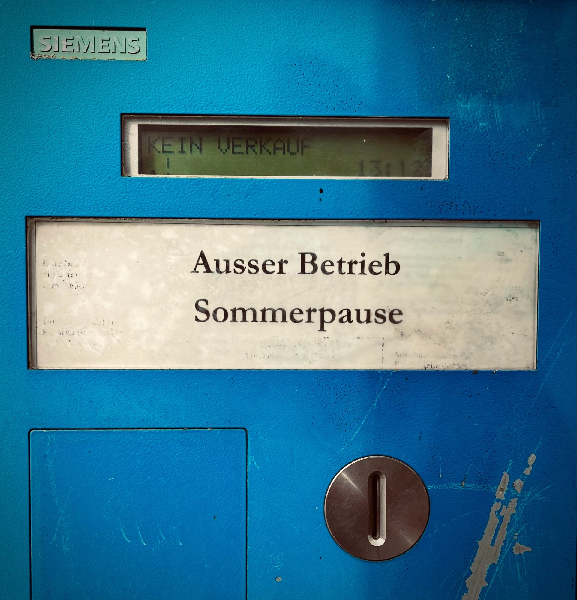 Blauer Parkscheinautomat mit dem Schild „Ausser Betrieb Sommerpause“