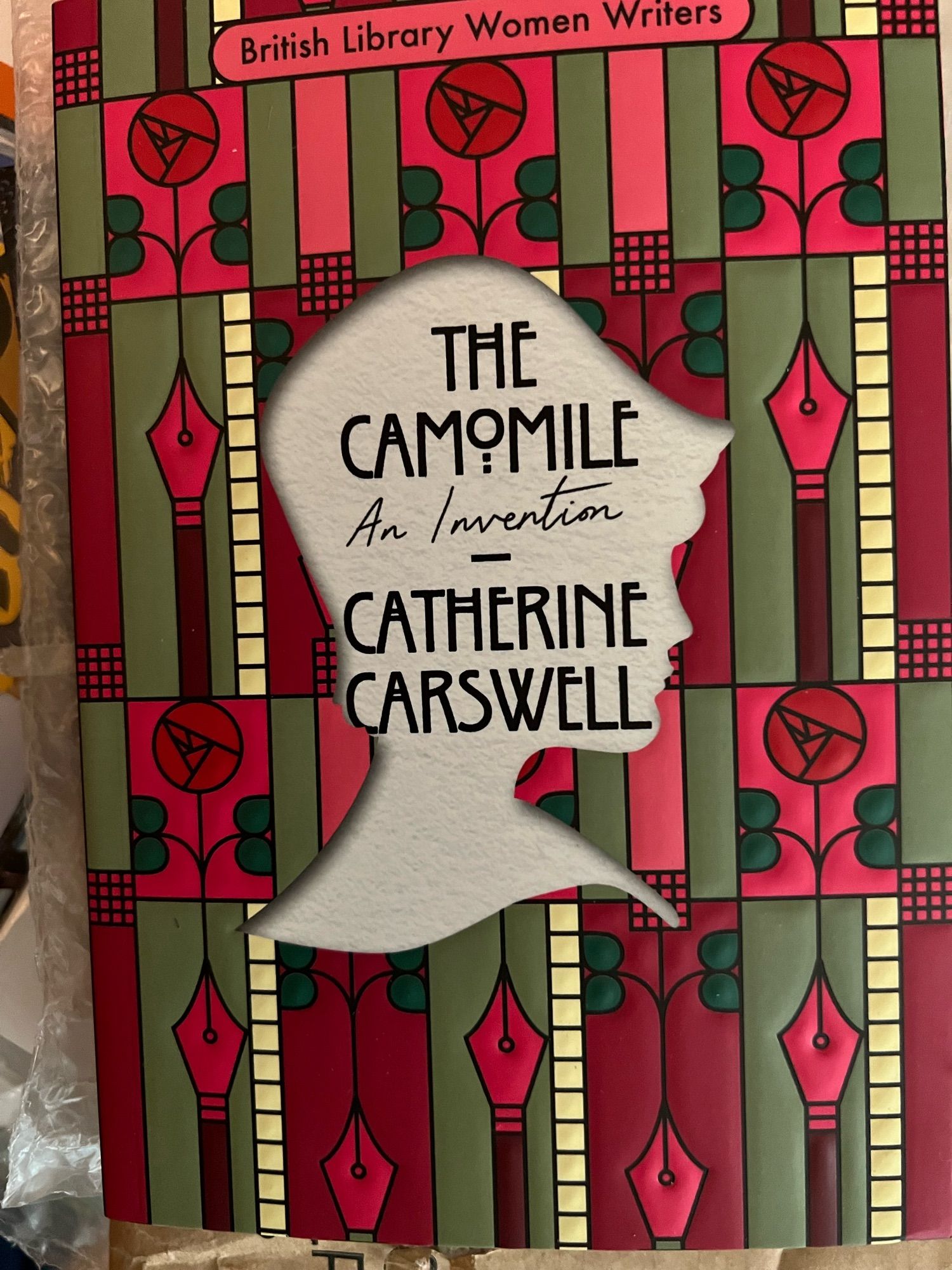 The Camomile Invention by Catherine Carswell - a silhouette of a 1920s woman on a background looking like a stained glass design by Rennie MacKintosh