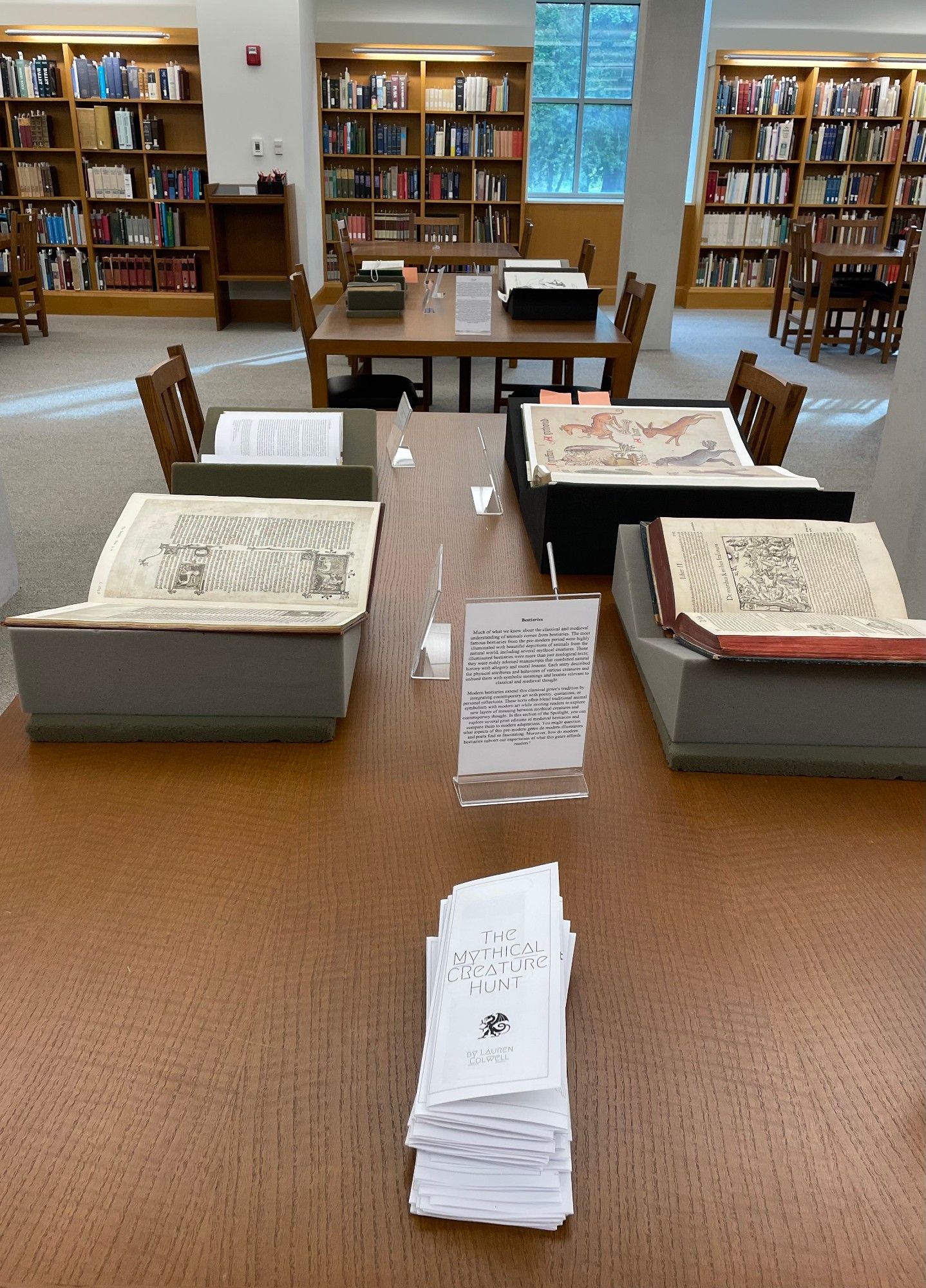 Image of Ohio State University's Thompson Special Collections reading room. Several books displayed open on tables, with labels and a stack of handouts in front.