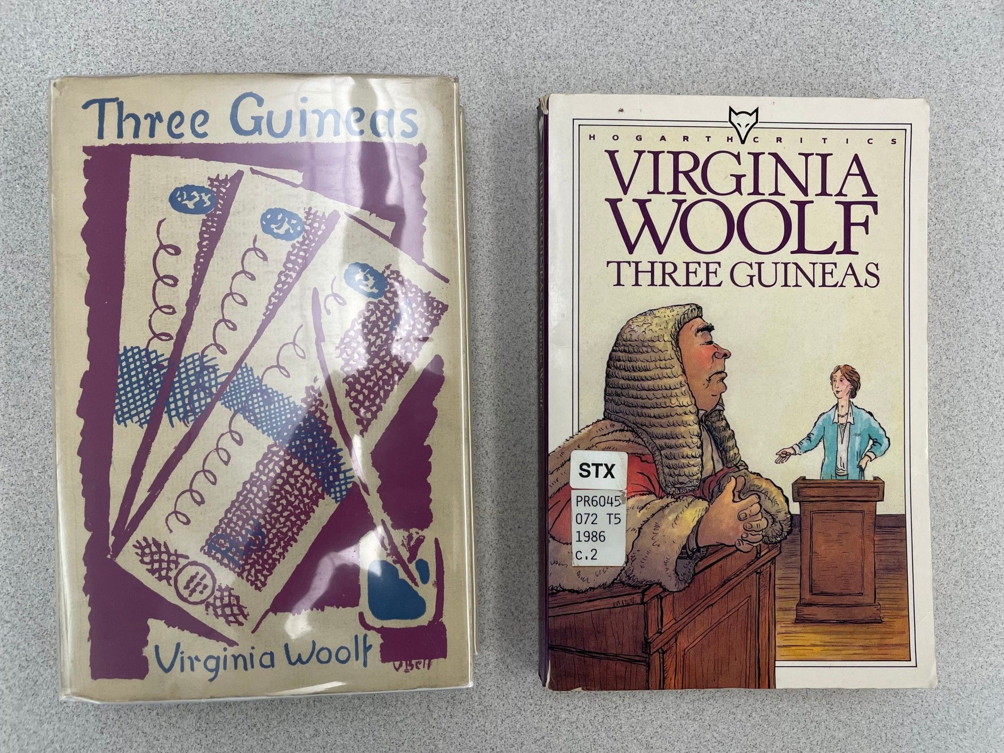 Two copies of Virginia Woolf's Three Guineas. Left is the first edition with a cover designed by Vanessa Bell; Right is a paperback featuring a cartoon of Woolf seemingly on trial before a judge.