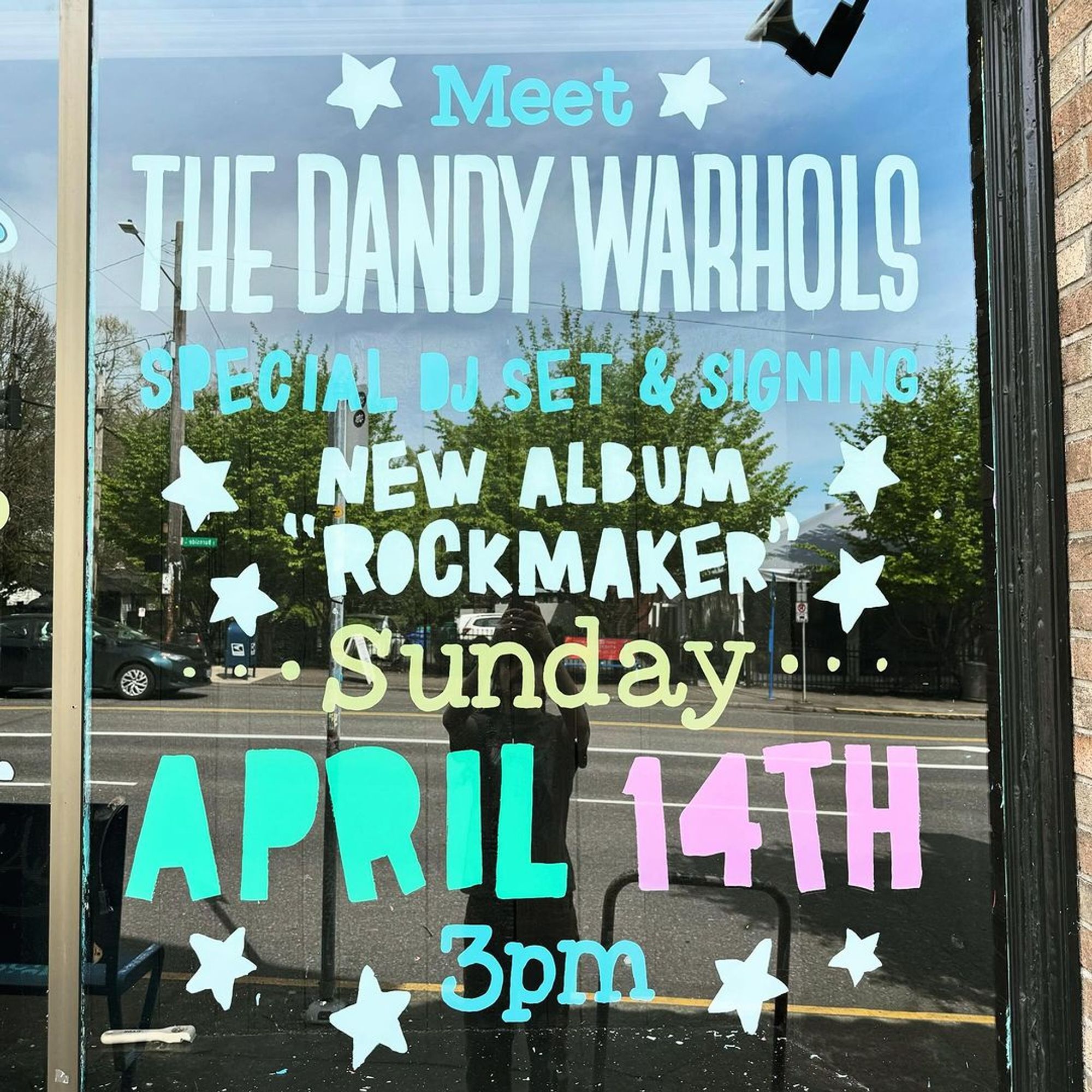 Hand painted record store window sign: "Meet The Dandy Warhols. Special DJ Set and Signing - New Album ROCKMAKER - Sunday April 14th 3pm"