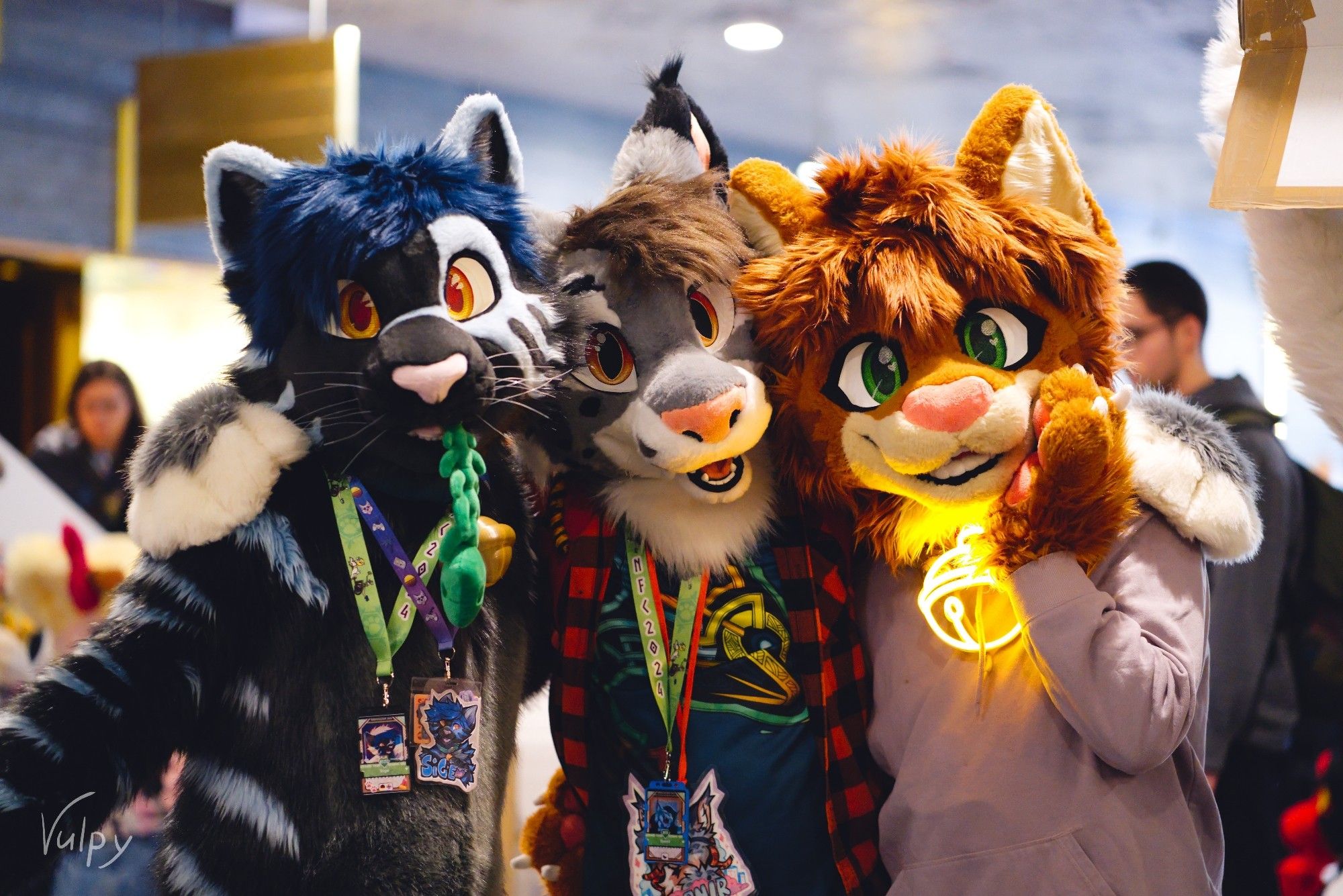 Three feline fursuiters posing for the camera