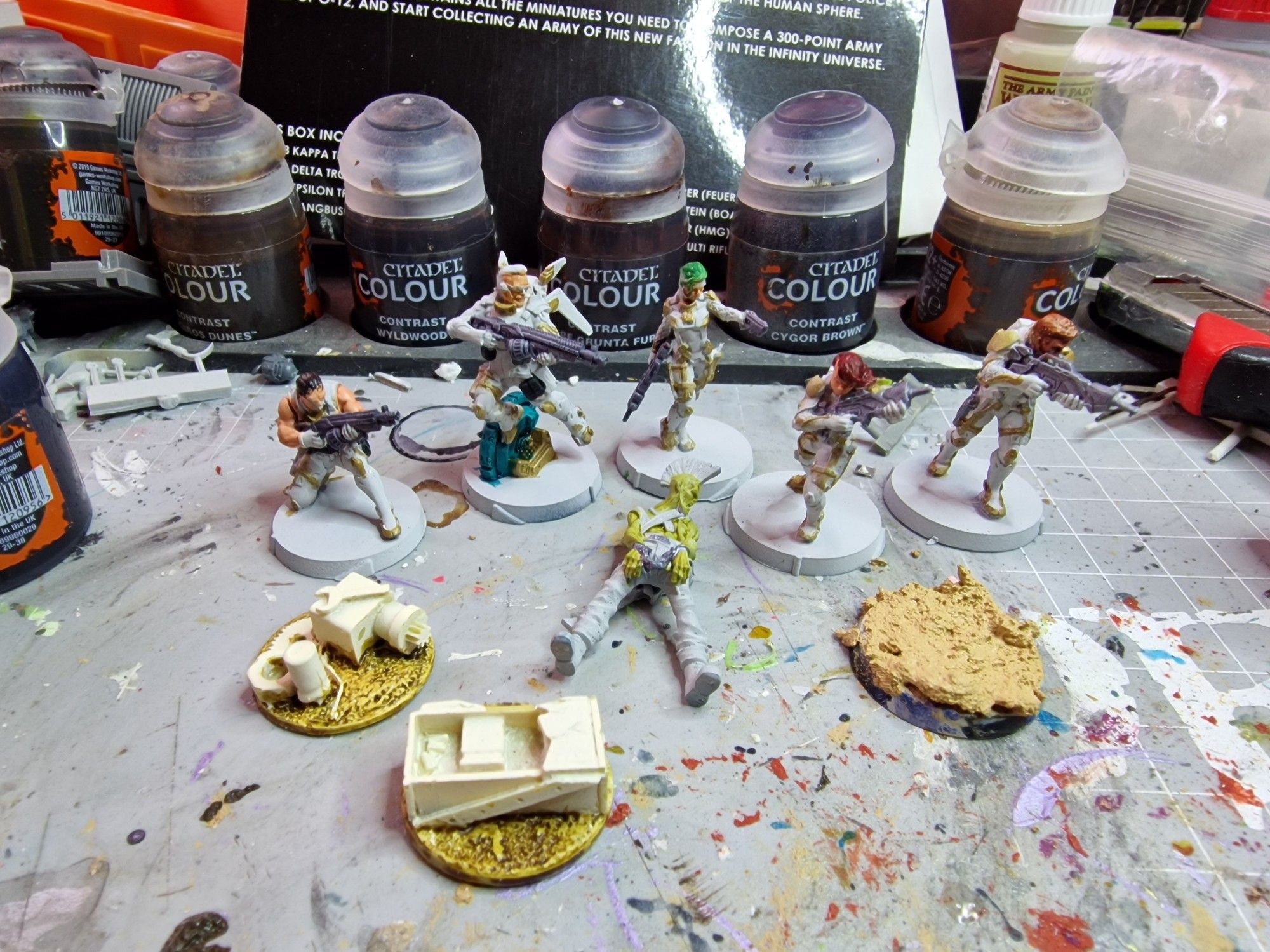 Al fondo 5 miniaturas de O-12 para Infinity a medio pintar. Más adelante un pocho de Punkapocalyptic y 2 marcadores también a medio pintar.