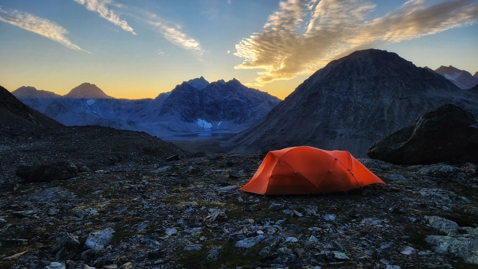 Mountains and a tents in evening light.