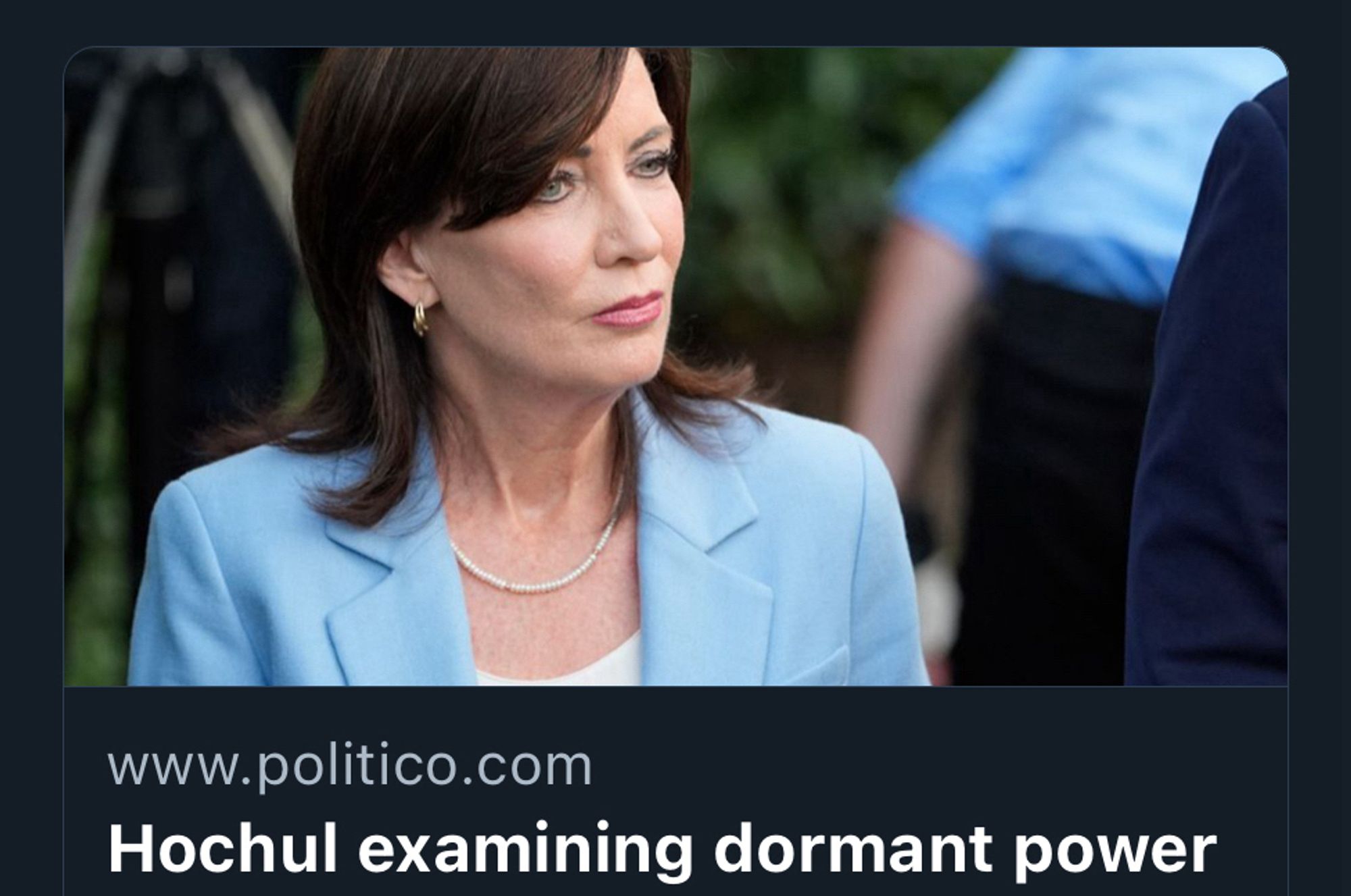 Picture of Kathy Hochul (white lady in her fifties with dark shoulder length hair) in blue suit with necklace

Headline: Hochul examining dormant power