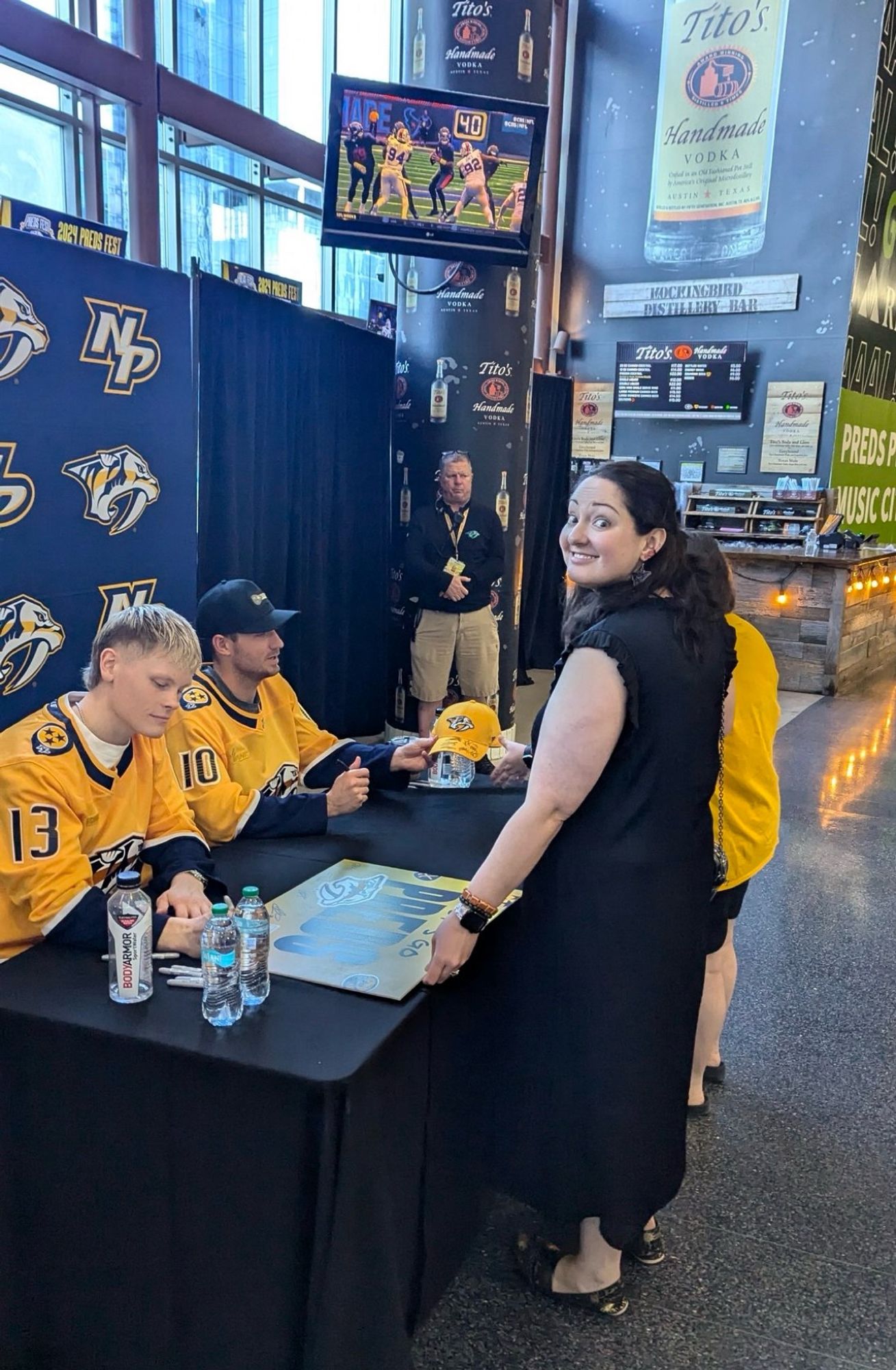 Juuso Pärssinen signing my sign. I’m smiling at the camera over my shoulder.