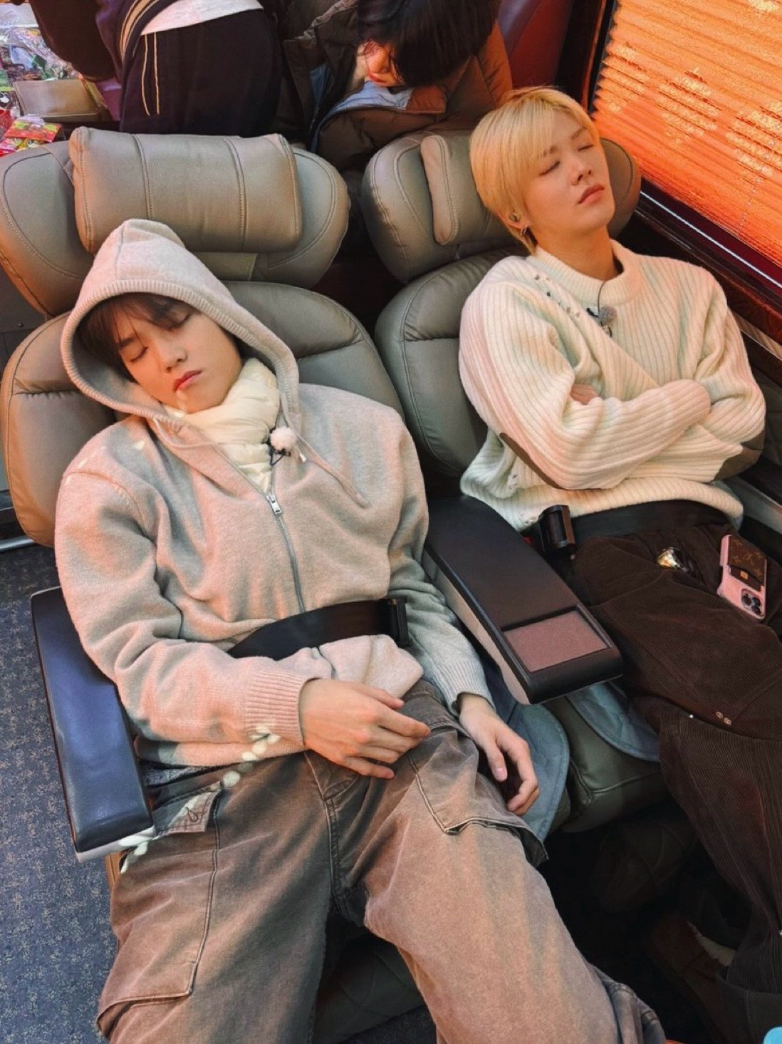 Taeyong and Yuta sleeping on the bus on the way to the filming location for their Be There For Me healing content. They are both reclined in their seats and wearing their seatbelts.