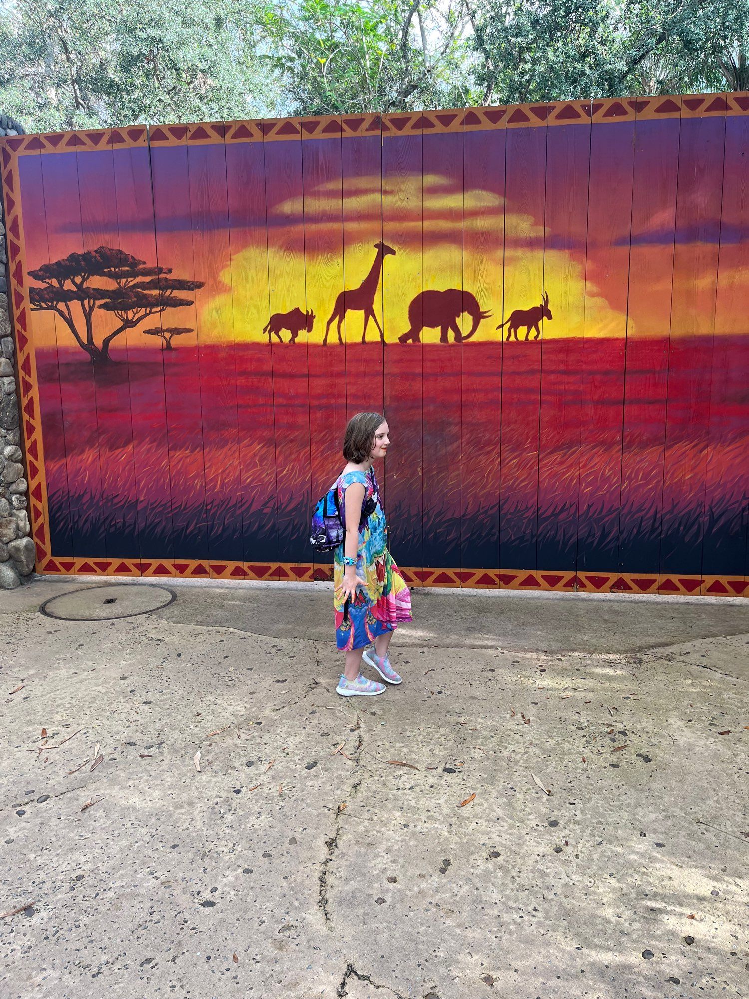 Kid walking in front of lion king mural.