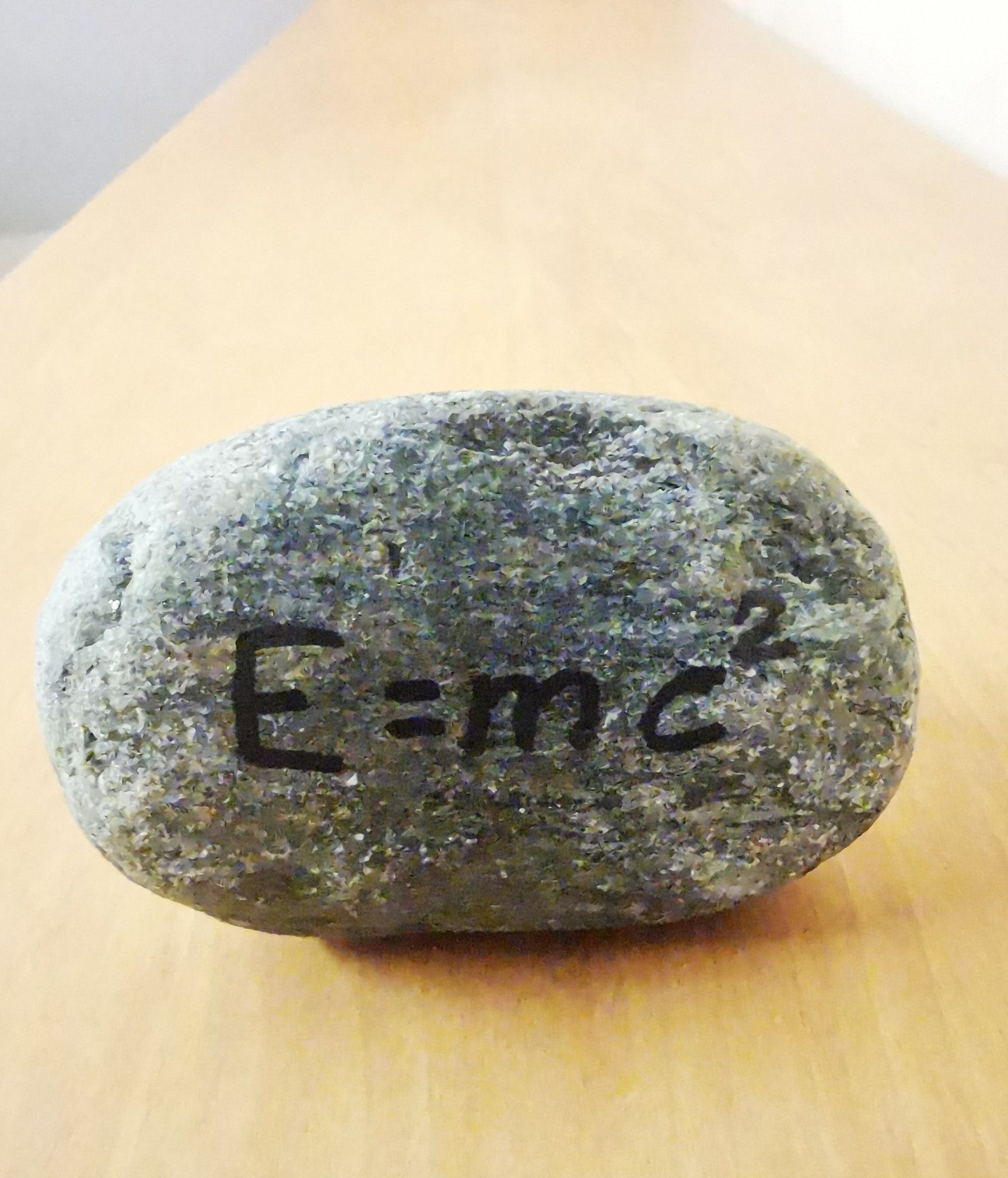 Ein Stein. Auf dem geschrieben steht E=mc^2