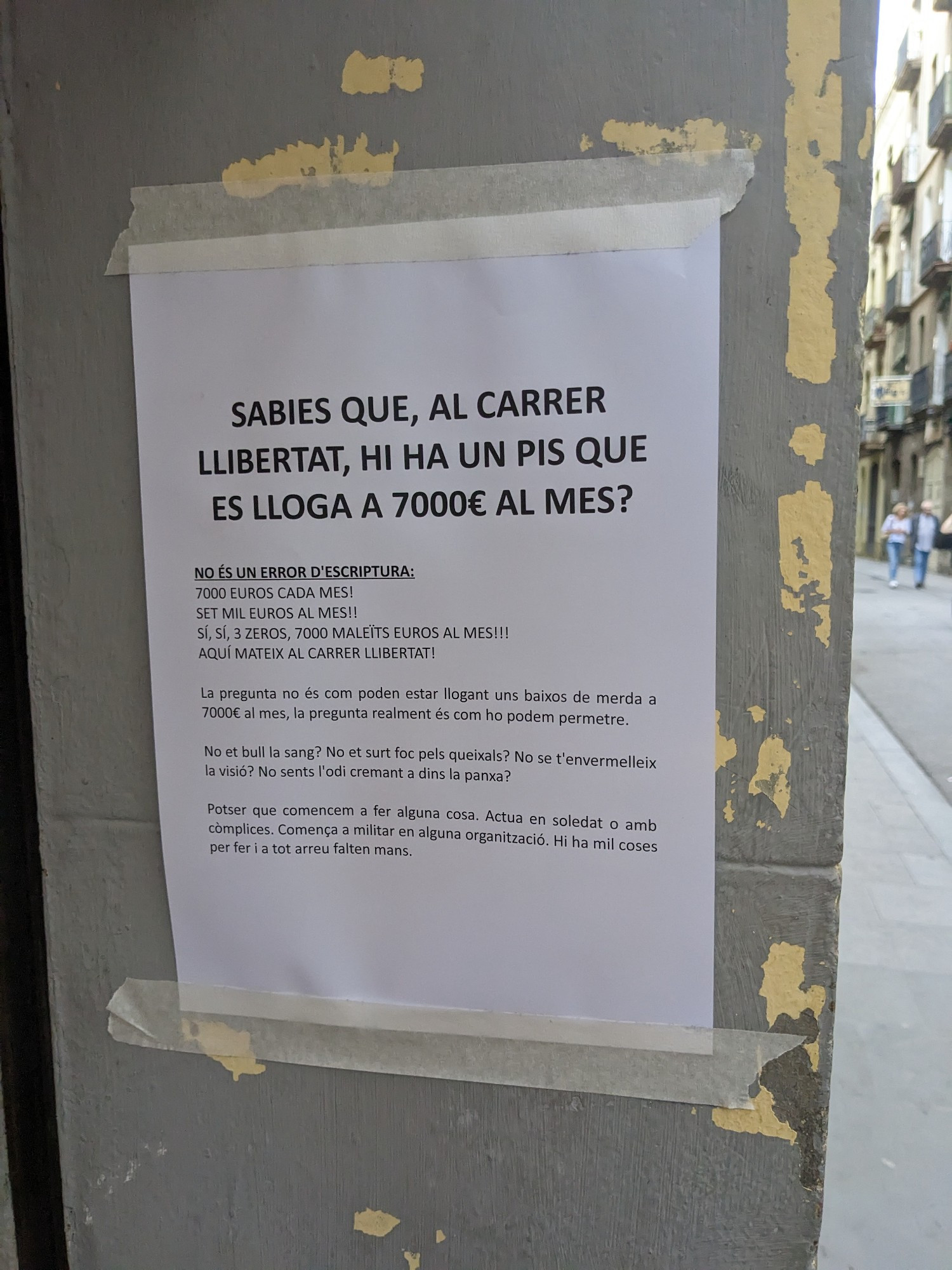 Un cartell que explica que al Carrer Llibertat hi ha uns baixos que es lloguen a 7000 euros.