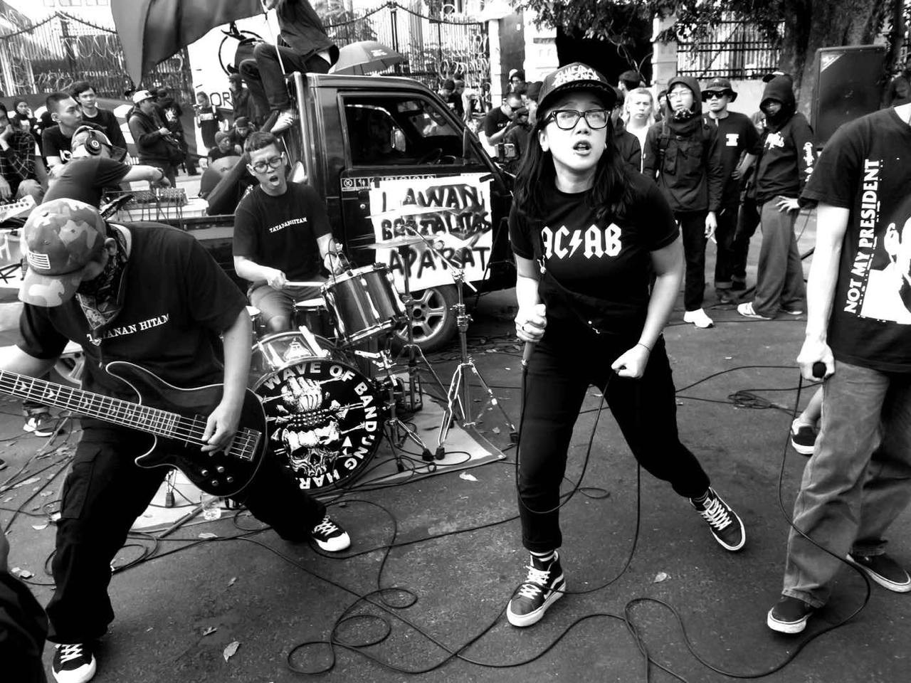 A hardcore band plays in the street during a demonstration in Bandung, Indonesia on August 28, 2024. The bass drum reads "New Wave of Bandung Hardcore!"