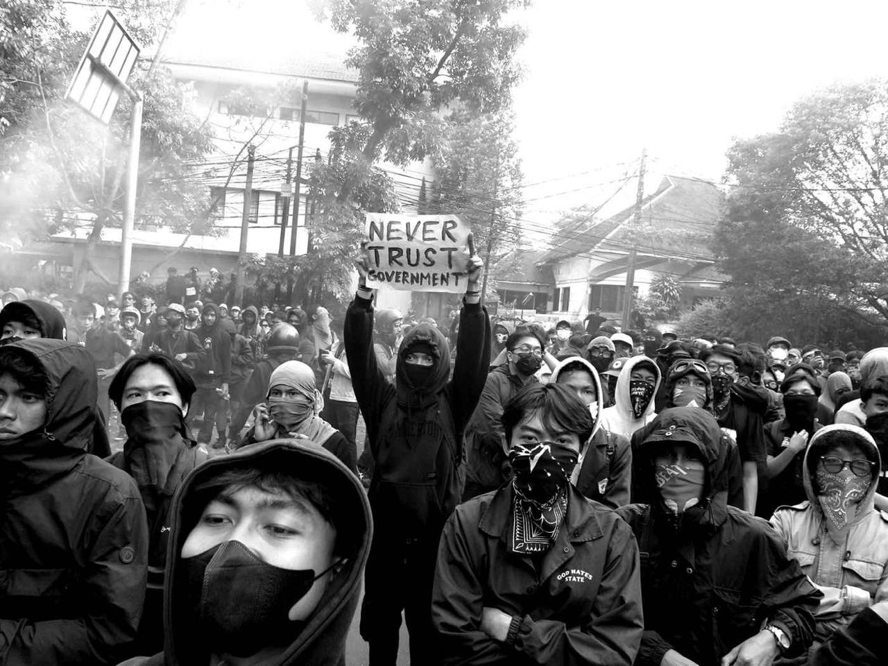 A protest in Bandung on August 22, 2024. One demonstrator holds up a sign reading "Never trust government."