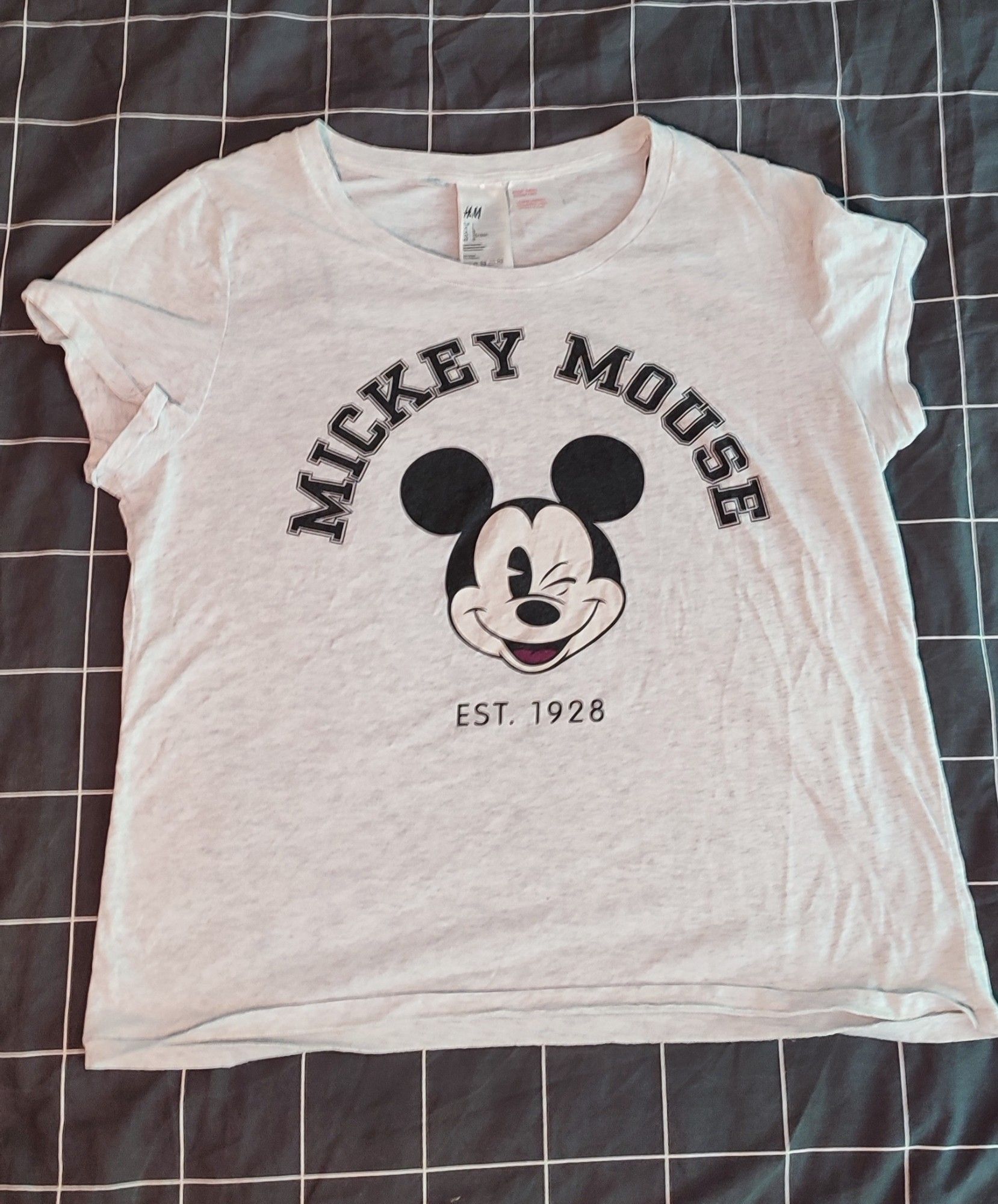 Ein weiß-gräulich meliertes Shirt mit Mickey Mouse Aufdruck. Es ist leicht cropped und als Schlafshirt gedacht, also sehr weich.
Größe L (Hersteller H&M)