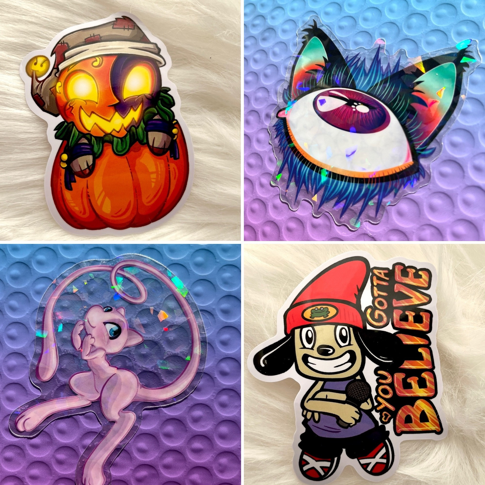 A grid of 4 sticker photos. 
Top left: a cute Chibi Jack O Moon coming out of a pumpkin
Top right: a surreal eyeball with long lashes and cat ears.
Lower left: Pokemon mew on a clear sticker with rainbow holo
Lower right: Parappa the Rapper holding a mic with the words “you gotta believe”