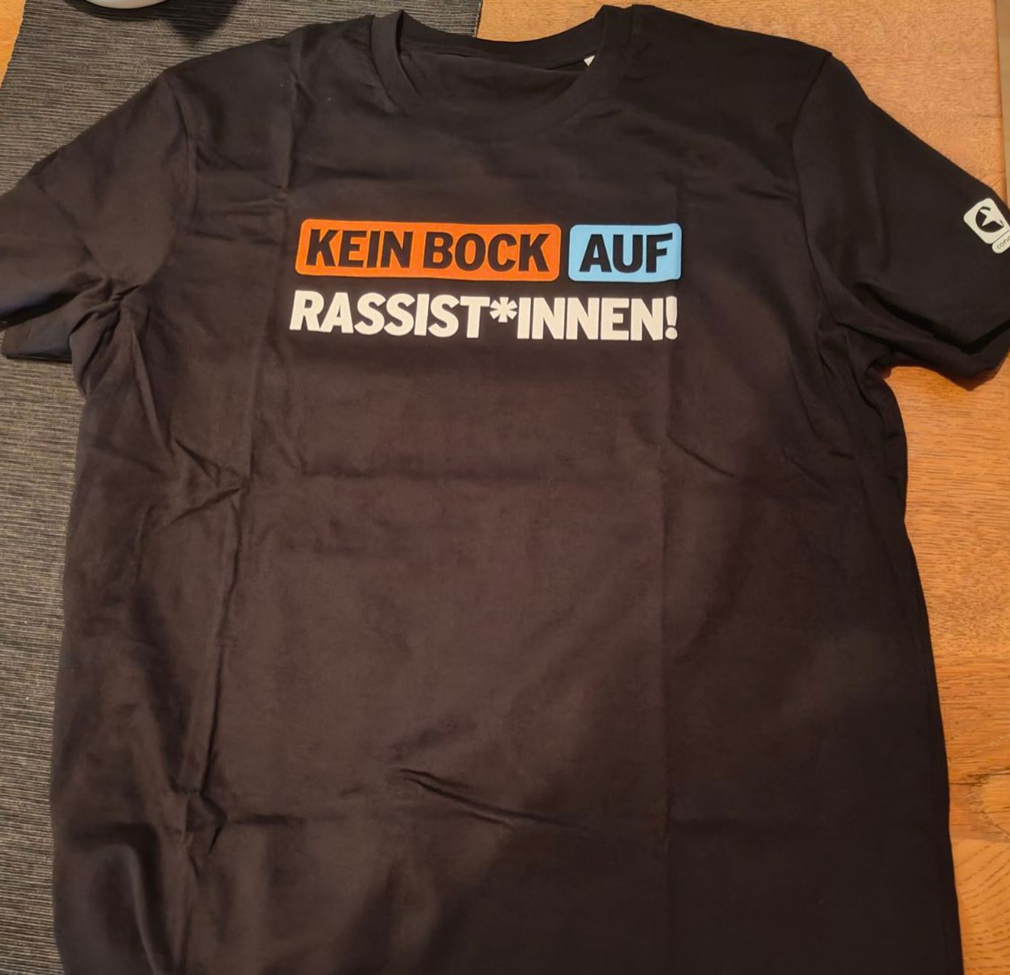 Schwarzes T-Shirt mit dem Schriftzug "Kein Bock auf Rassist*innen!" 
von Congstar