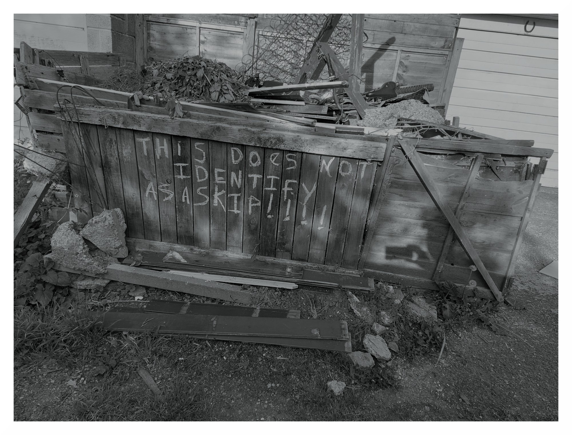 Rubbish dumped in a skip-sized container with a sign "This does not identify as a skip!!!!"