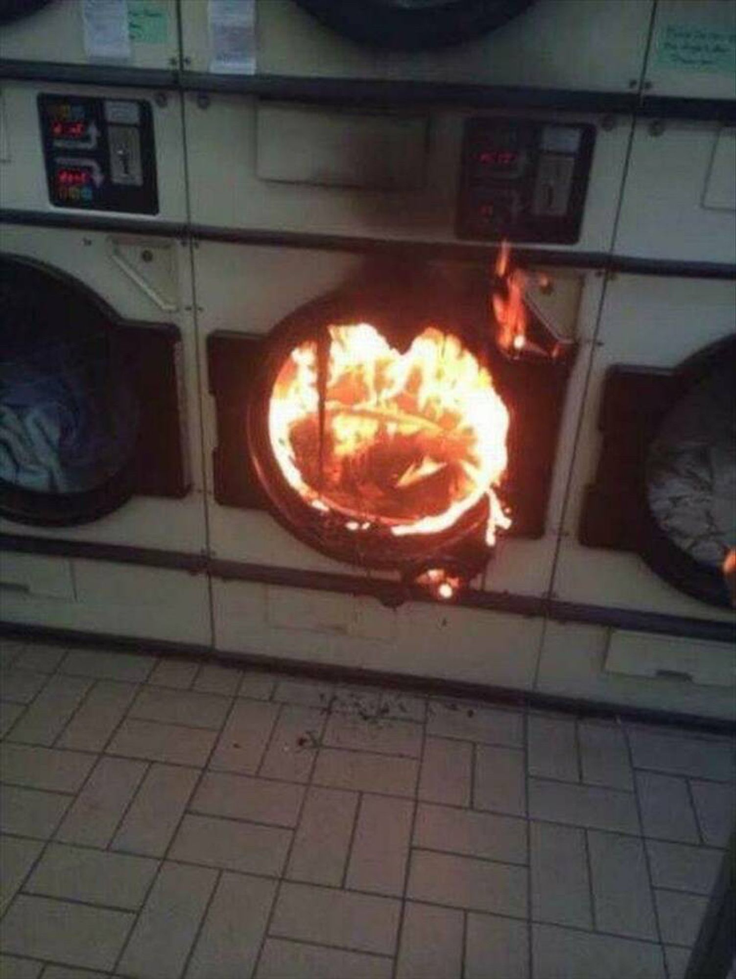 A laundry dryer on fire (flames coming from inside the machine)