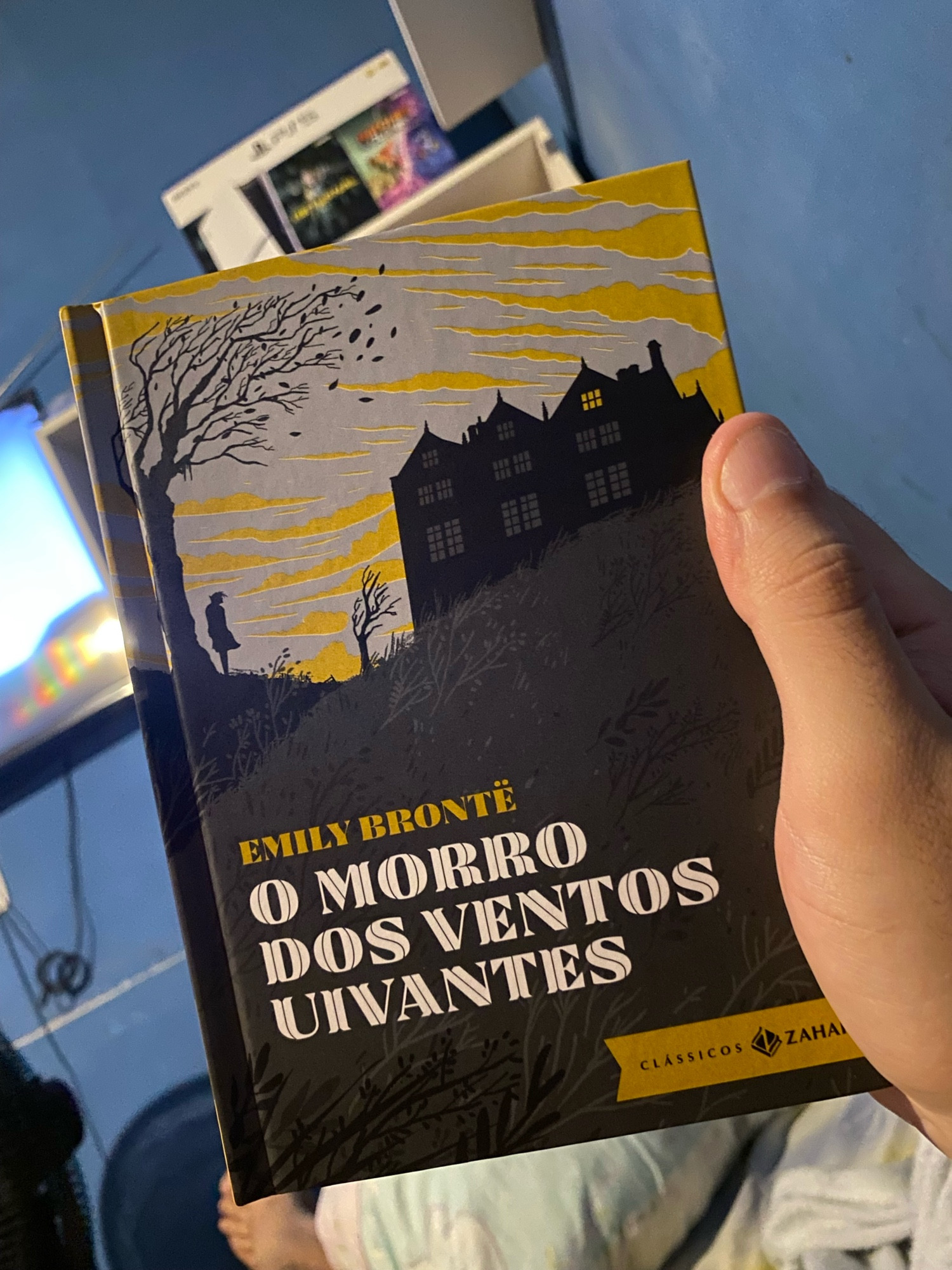 Uma mão segurando o livro “O Morro dos Ventos Uivantes” edição da coleção de bolso luxo da editora Zahar