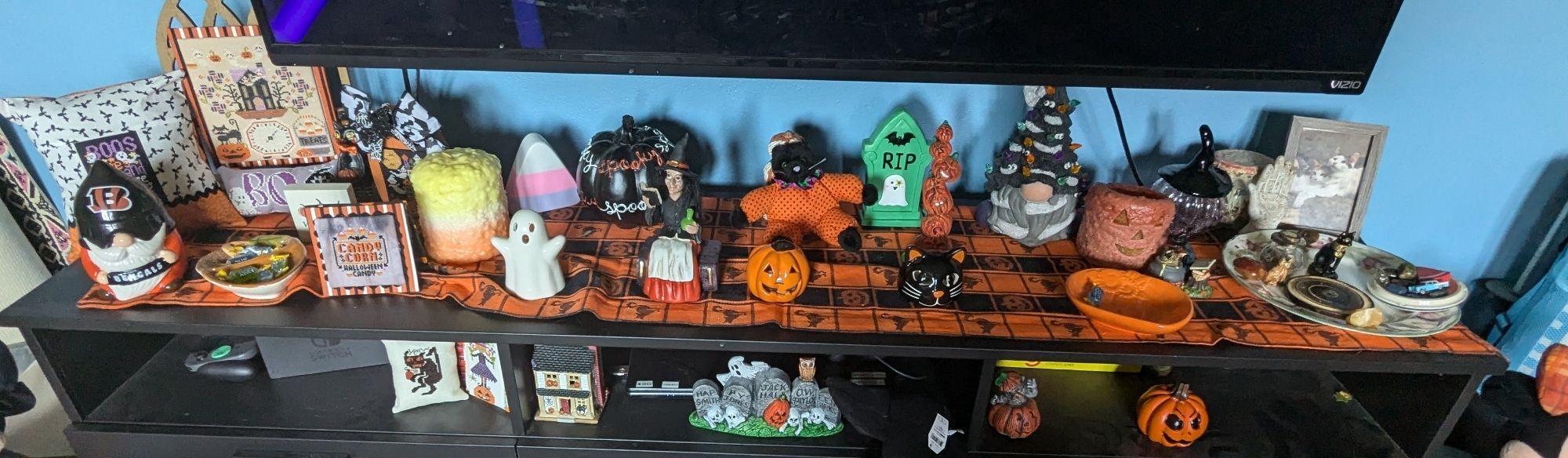 A TV stand with Halloween knick nacks all overit