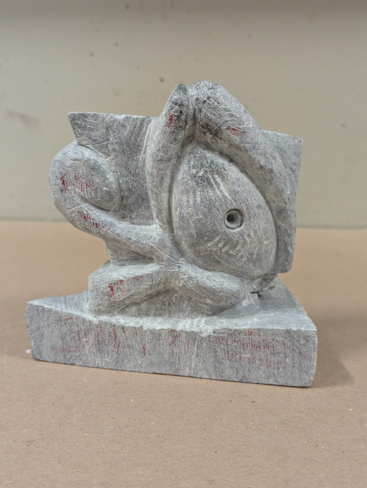 A stone carving of the eye of ra, as if emerging from a rock base. It is facing the viewer

The sculpture is a triangle with a big eye on the front. The eye has a lower swoop facing the left