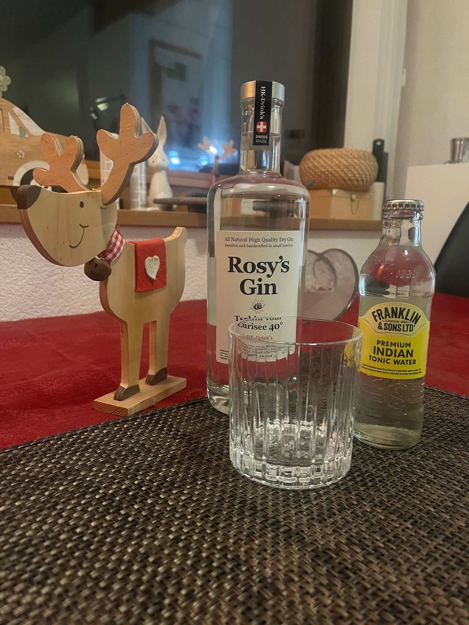 Eine Flasche Rosy‘s Gin & ein Premium Indian Tonic Water mit leicht weihnachtlicher Dekoration.