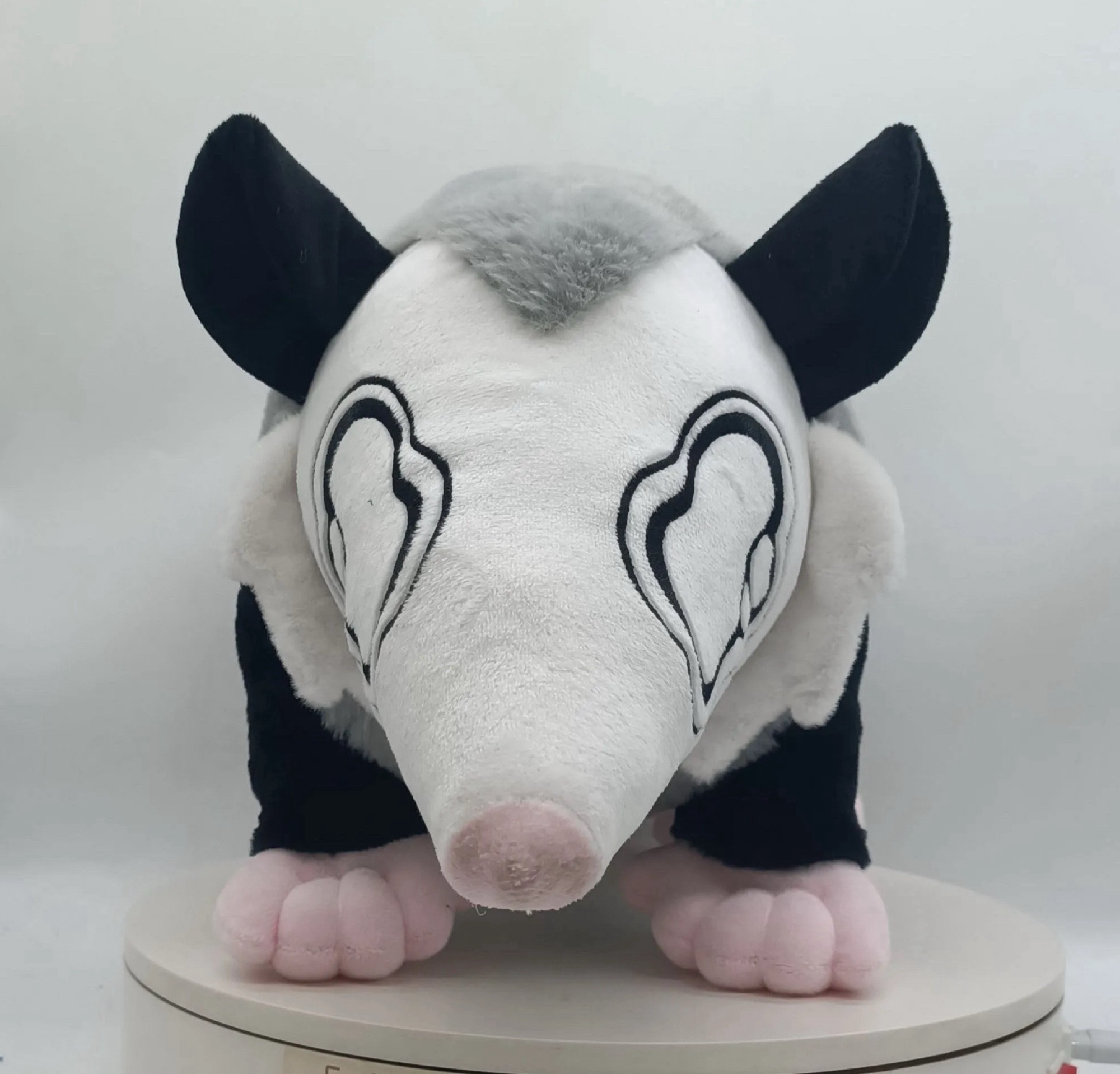 Front facing sad opossum plush