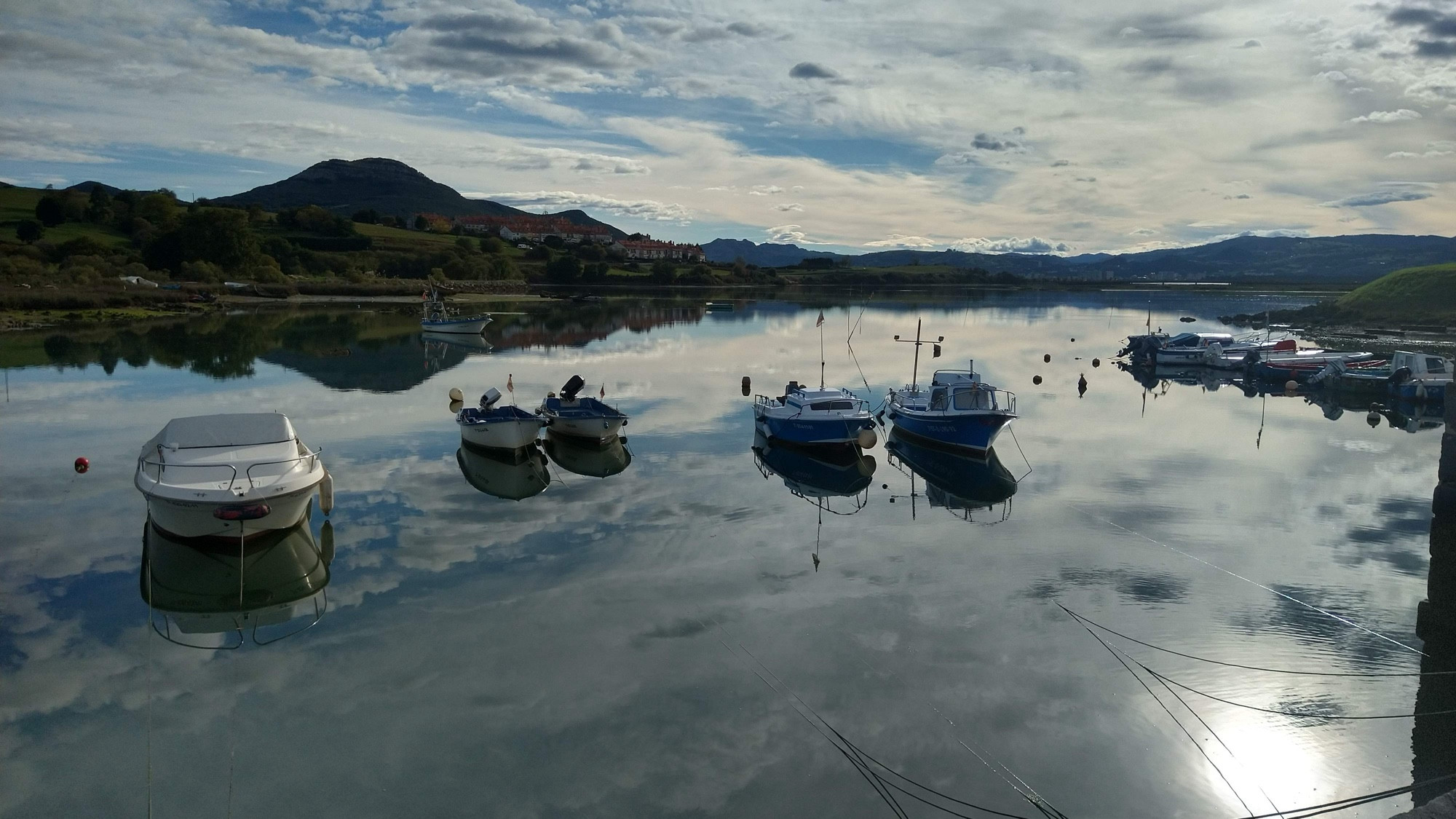 Foto del embarcadero de la Ría de Argoños con el agua reflejando todo como un espejo