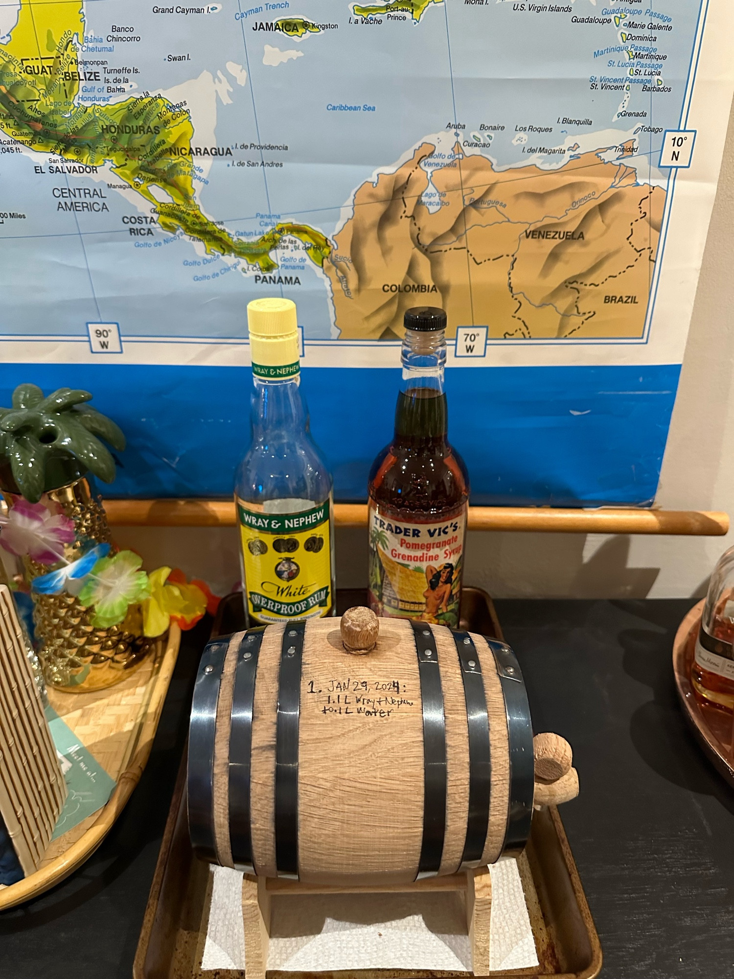 Barrel with the partial bottle of Wray & Nephew and a vintage bottle with a classic Trader Vic’s grenadine label, filled with dark amber aged Wray