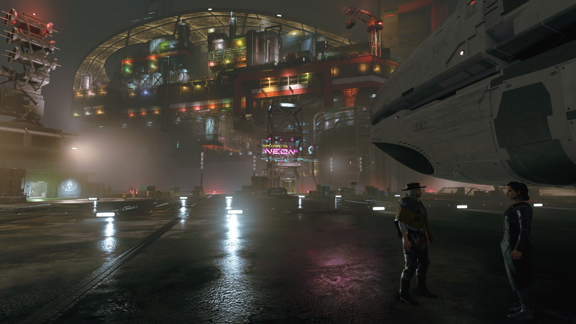 A screenshot from the video game Starfield: 2 people standing next to the bow of a white spaceship. One is wearing a poncho with a floppy hat, the other one is wearing a long dress. In the background is a sea of lights from what looks to be an oil rig.