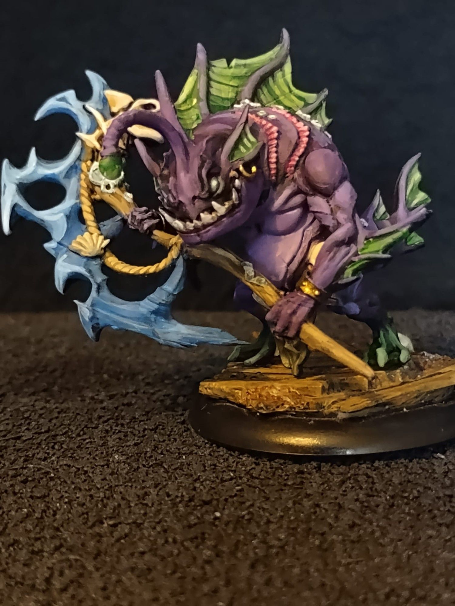 A purple and green Murlock / Fish man with a magical staff.