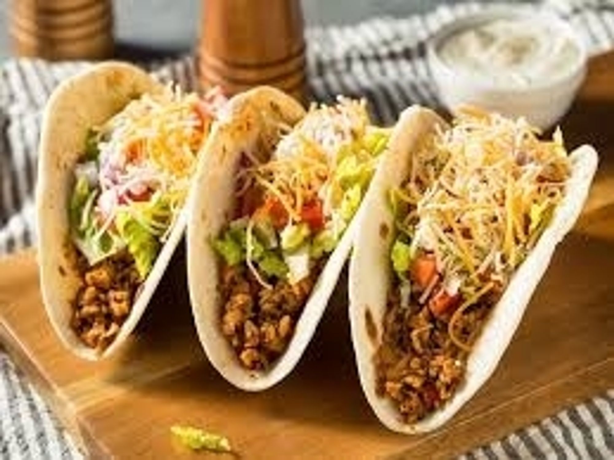 an image depicting three tacos on a table