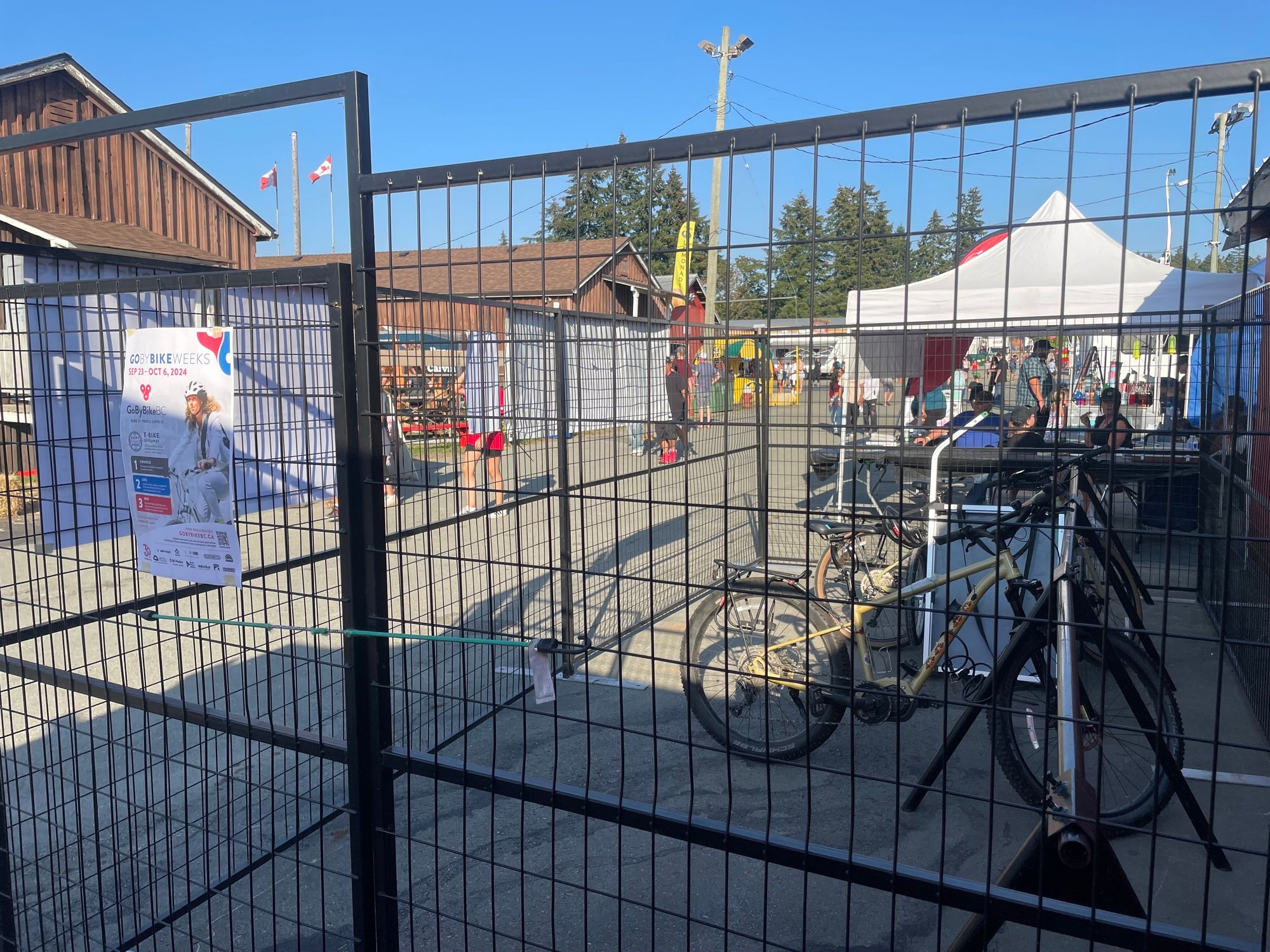 Behind the fence are two bicycles parked in storage.