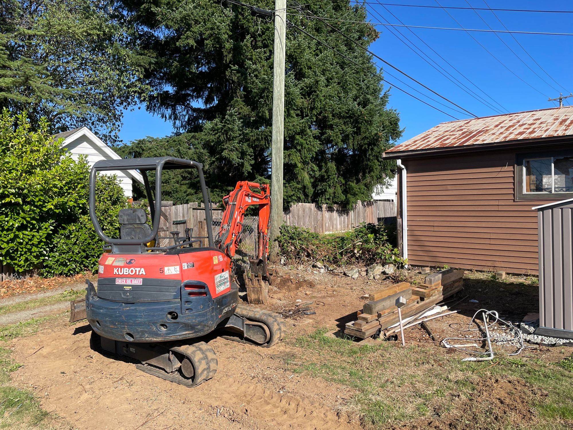 A small orange orange excavator in the yard.