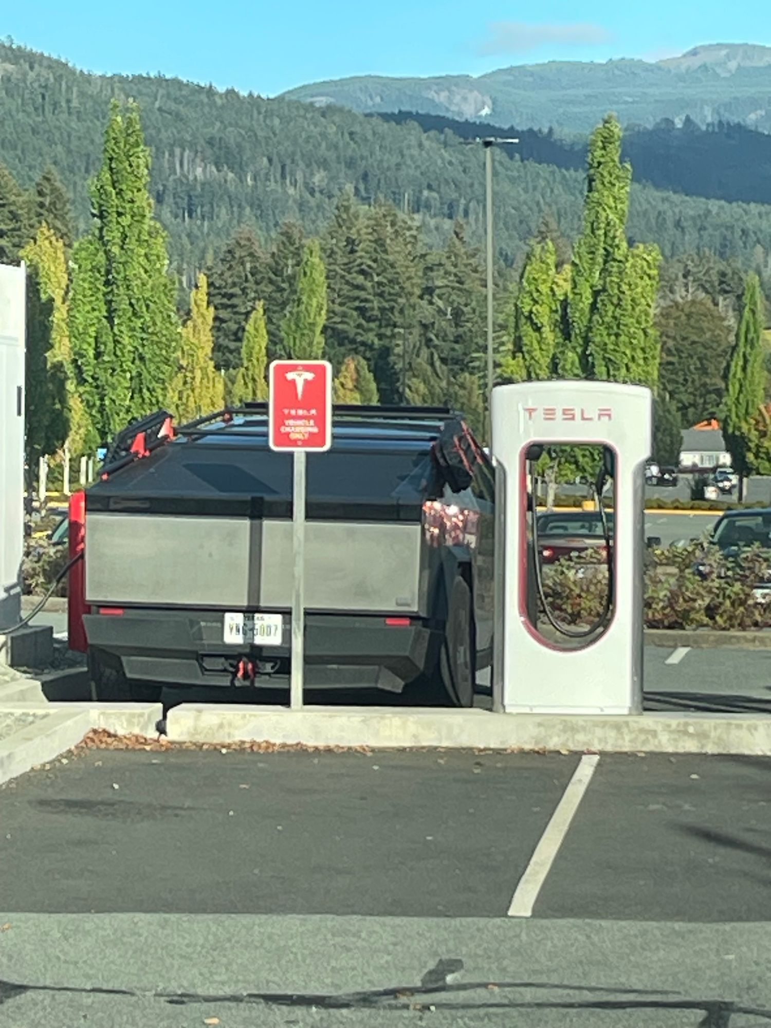 A picture of the back of a Tesla cyber truck. Parked in a Tesla charging zone.