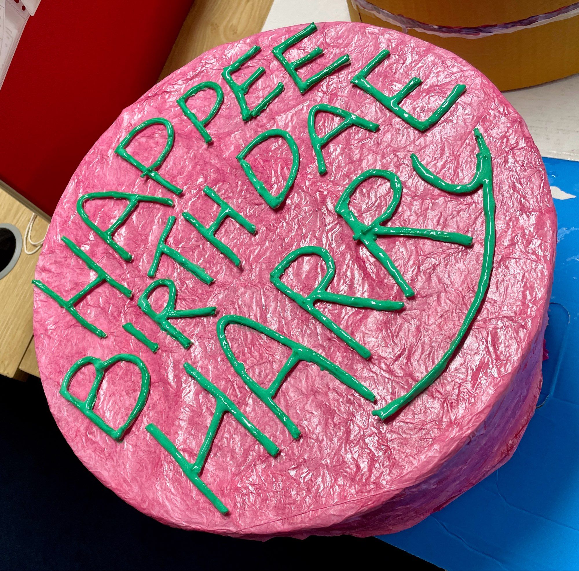 The top/outside of the pink Birthday Cake box has green ‘icing’ (string liberally coated in green tinted PVA glue) that reads - HAPPEE BIRTHDAE HARRY.