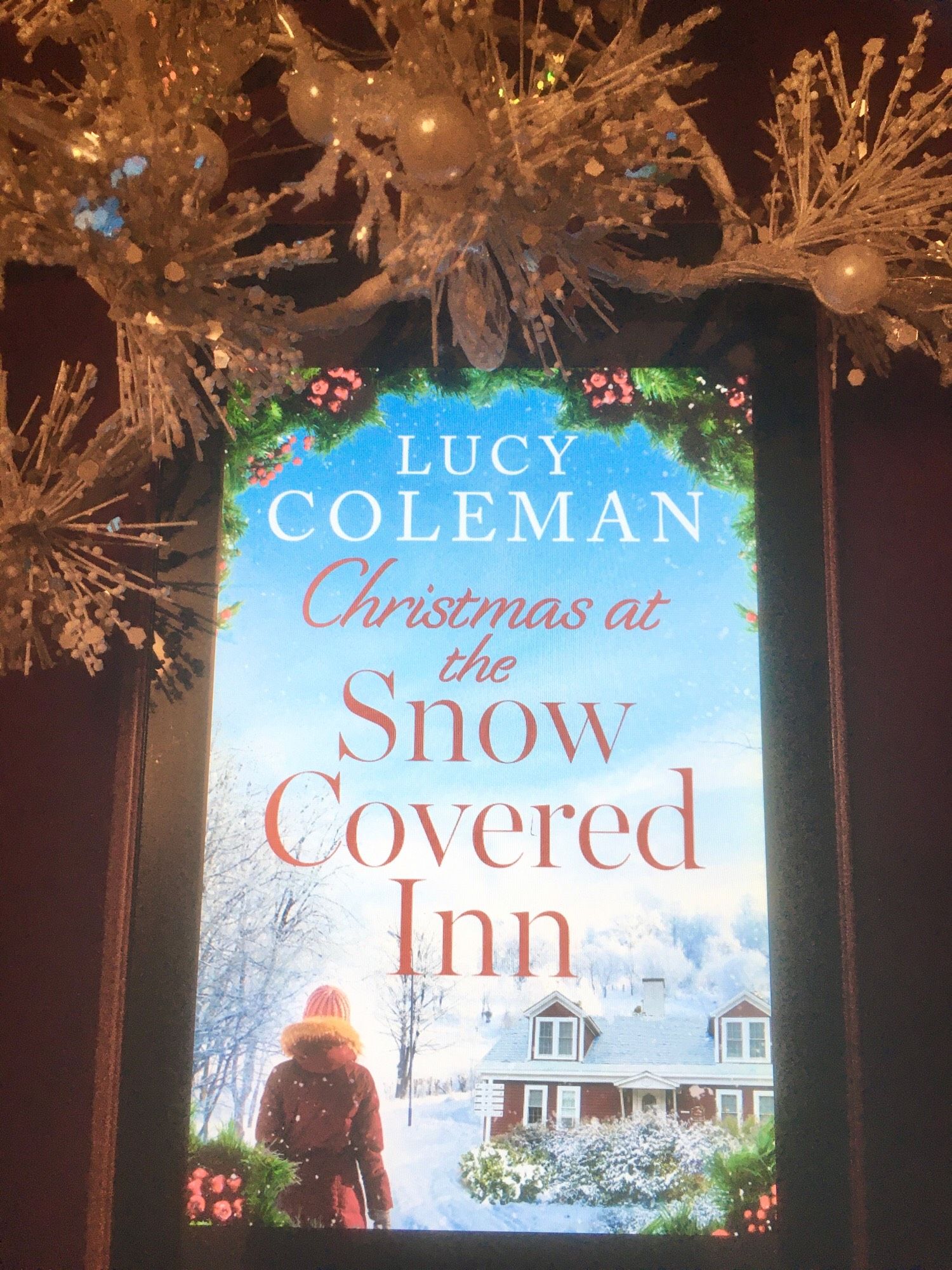 book cover of Christmas at the Snow Covered Inn by Lucy Coleman with snowflake and bead decorations at the top