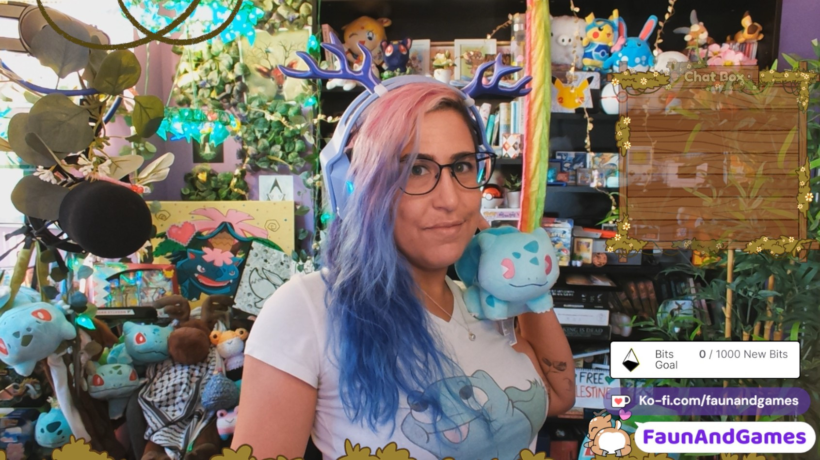 Nonbinary stream FaunAndGames is wearing a purple gaming headset with purple antlers. They are holding up a Bulbasaur Pokémon plushie and smiling at the camera.