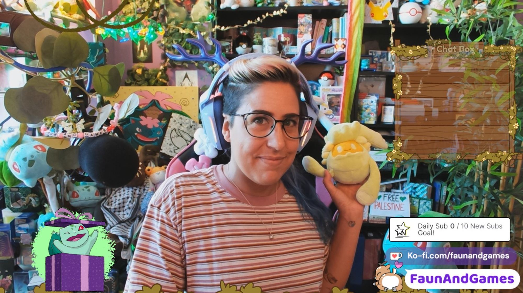 Nonbinary streamer FaunAndGames is wearing a purple gaming headset with purple antlers. They are holding up a Comfey plushie towards the camera and smiling. On the bottom left is an animated Bulbasaur jumping out of a present.