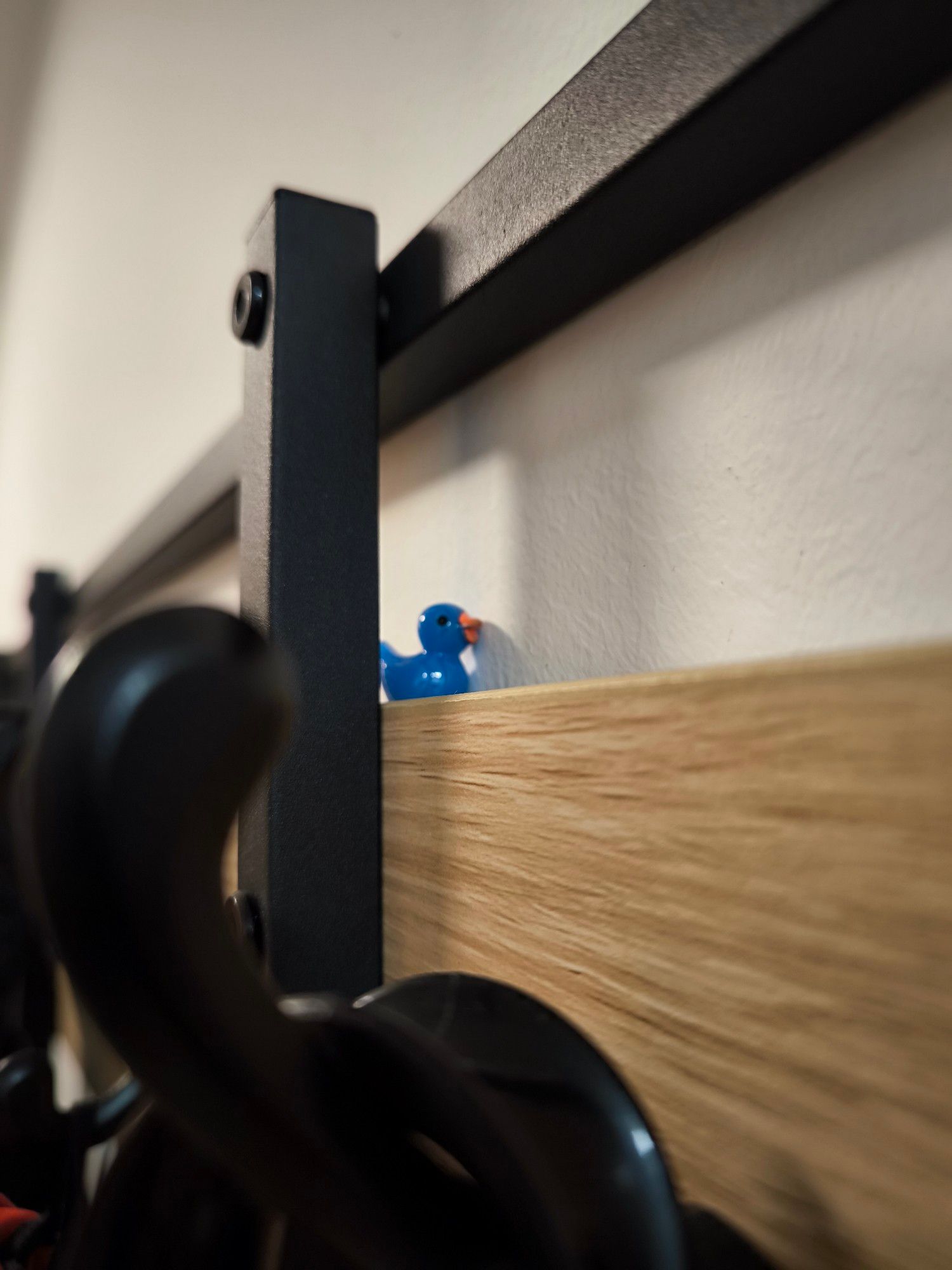 eine blaue entenfigur versteckt auf der garderobe im flur